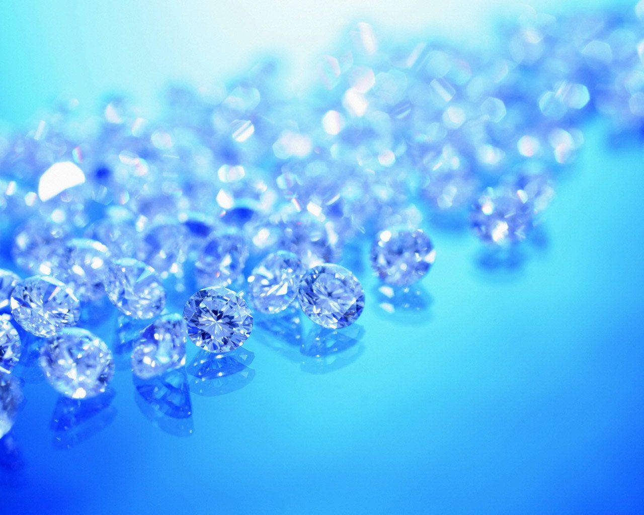 Larger-than-life blue diamond crystals sparkle brilliantly against a white background. Wallpaper