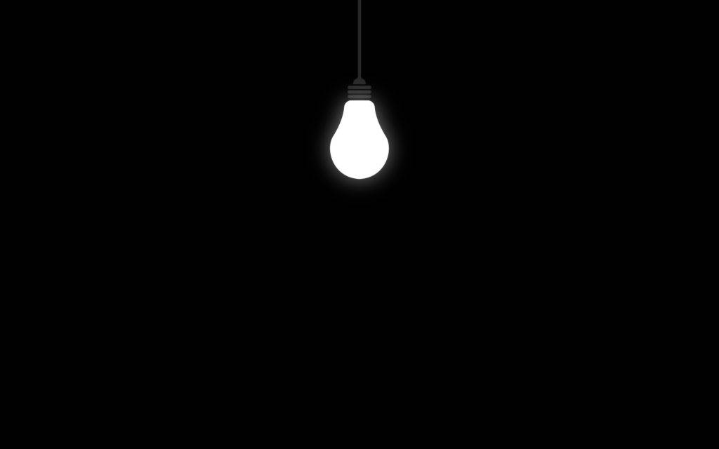 Light Bulb In Solid Black Room Wallpaper