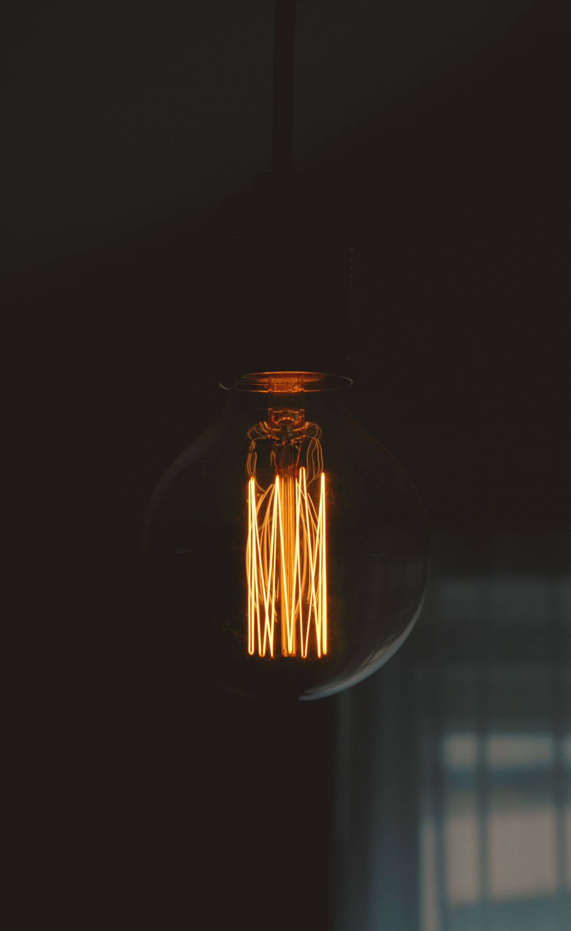 Illuminated OLED Lightbulb Against a Dark Background on an iPhone. Wallpaper
