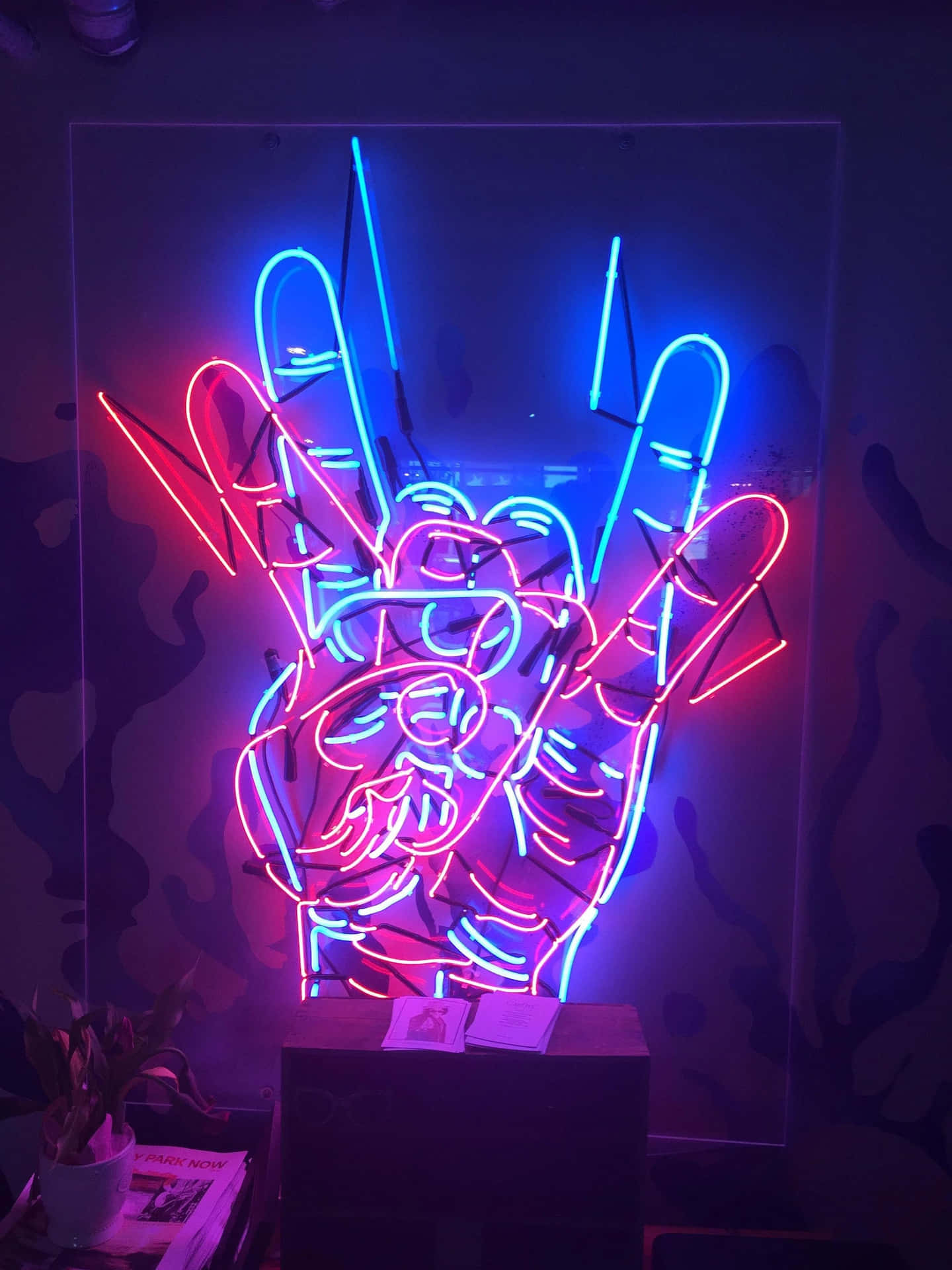 A Neon Sign With A Hand In The Middle