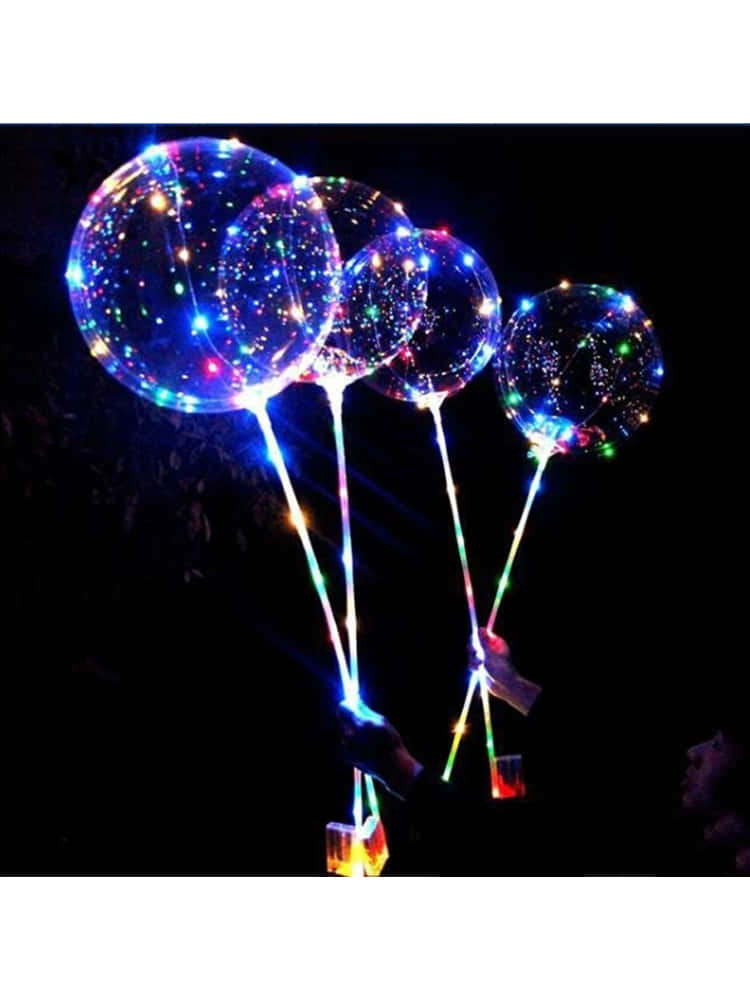 Three Light Up Balloons With Lights On Them