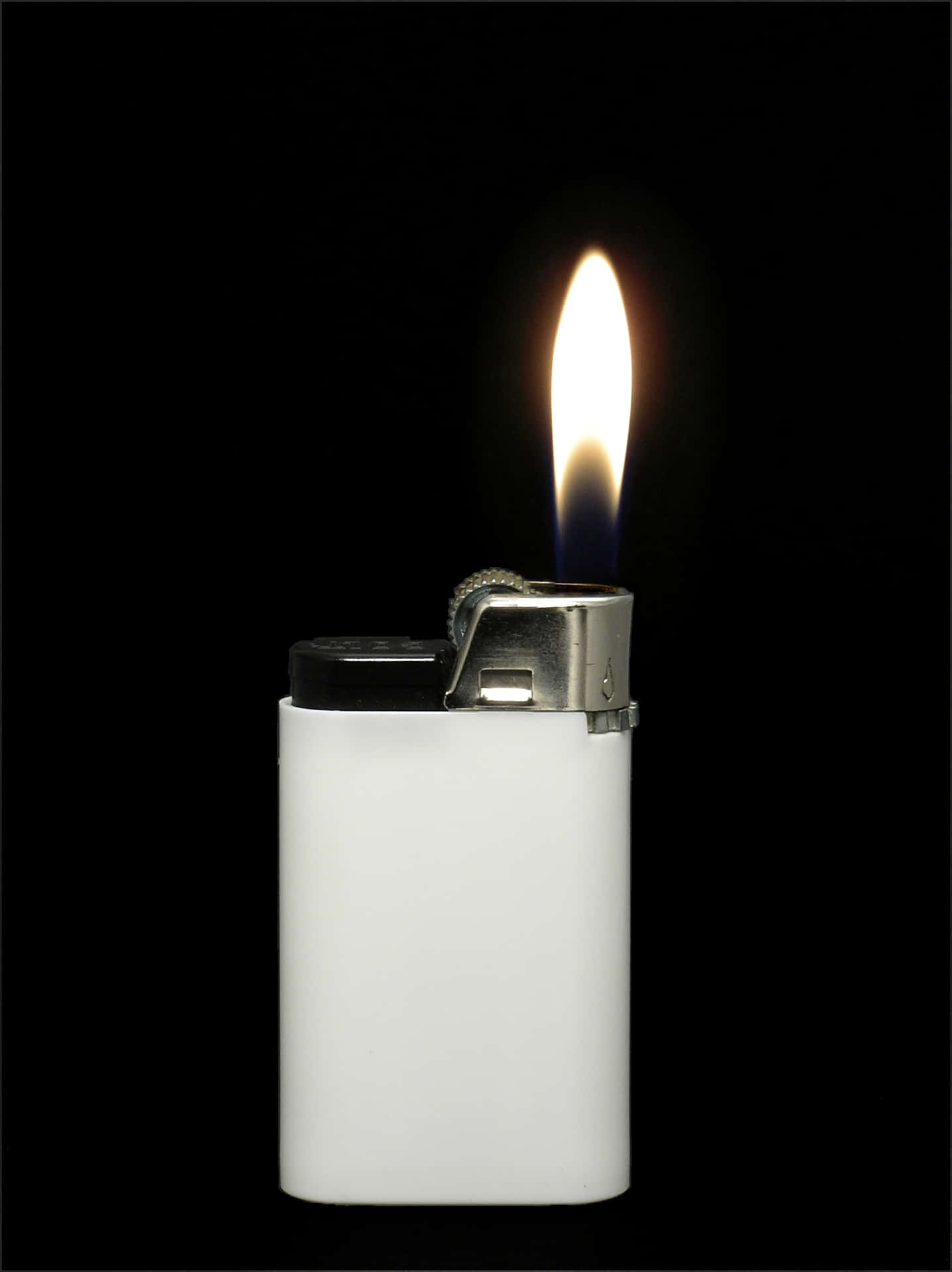 A shining lighter sparks flame in the darkness
