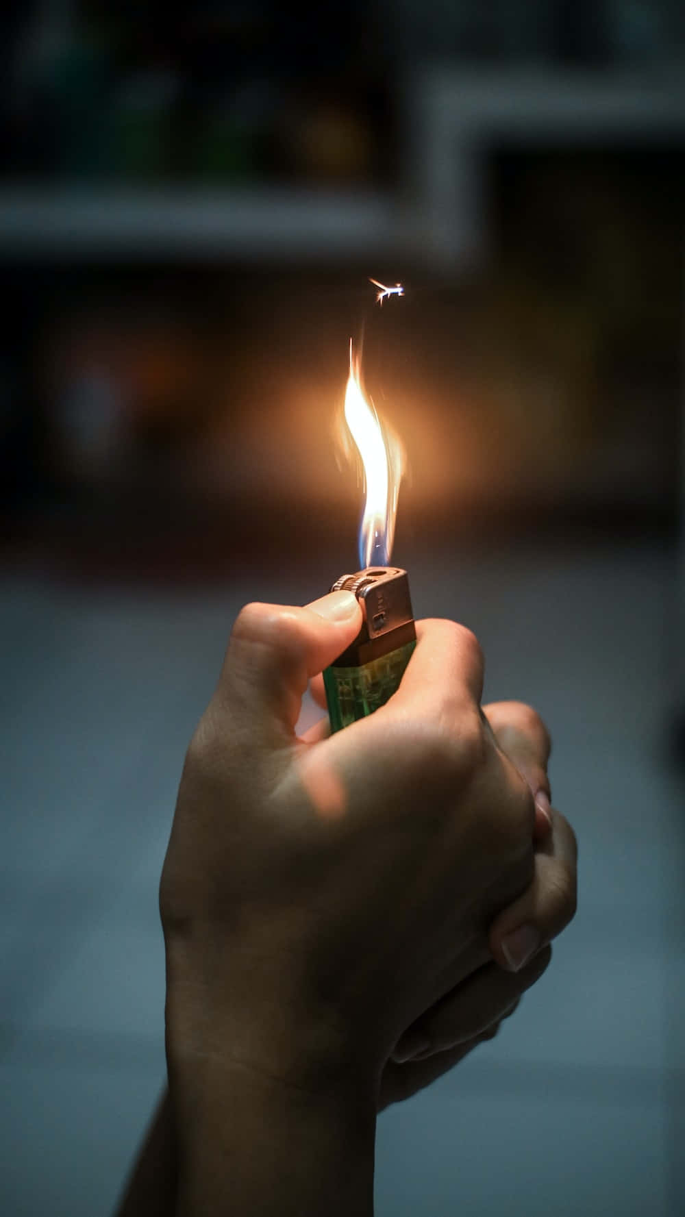 A Person Holding A Lighter In Their Hand