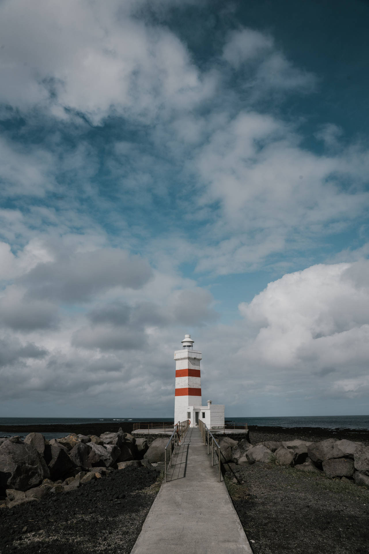 Majestic Lighthouse Under Gray Cloudy Skies Wallpaper