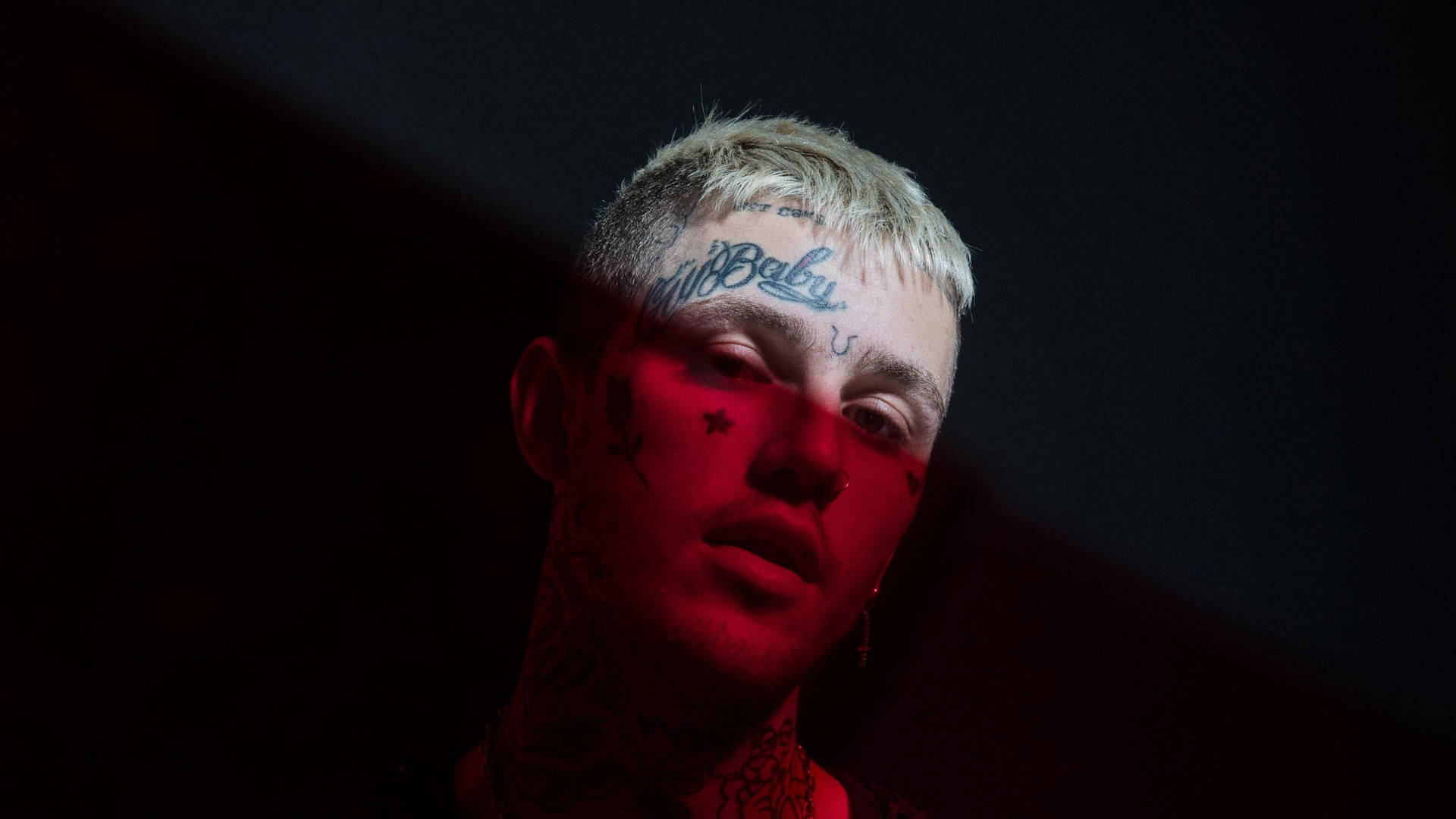 The late Lil Peep in a striking red aesthetic portrait Wallpaper
