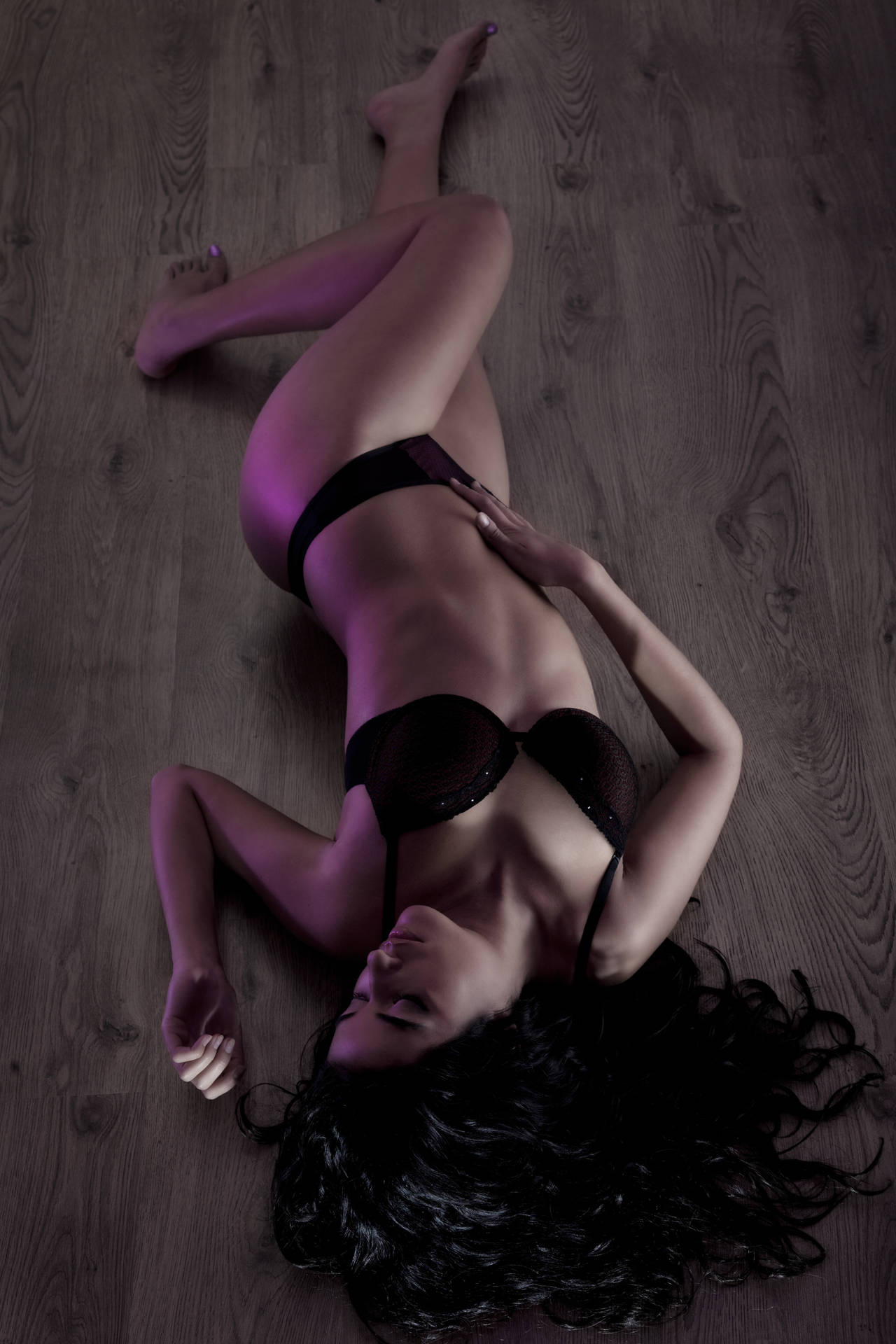 Lingerie, a bra and black panties, lying on a beige tile floor