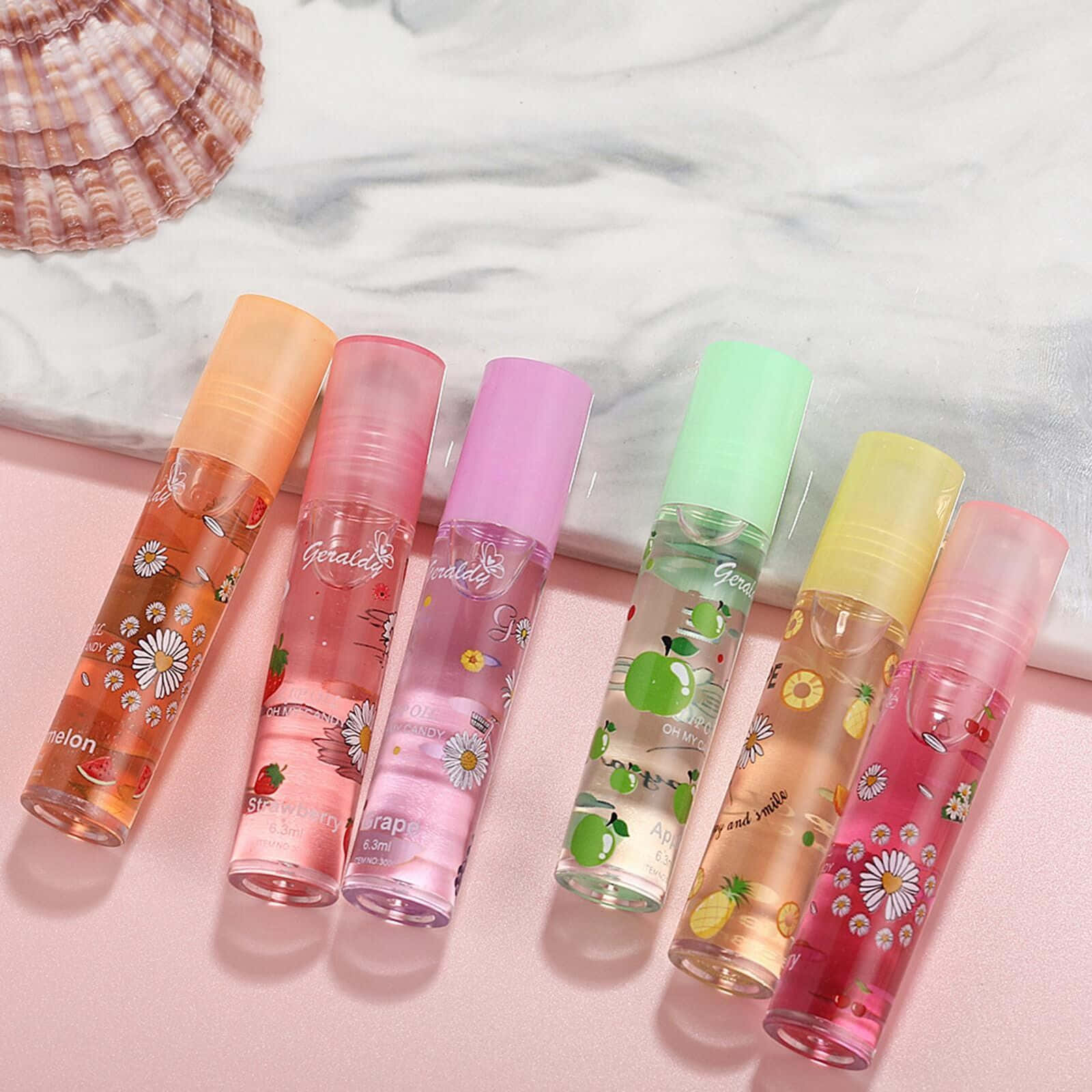Five Different Colored Bottles Of Perfume With Shells On Them