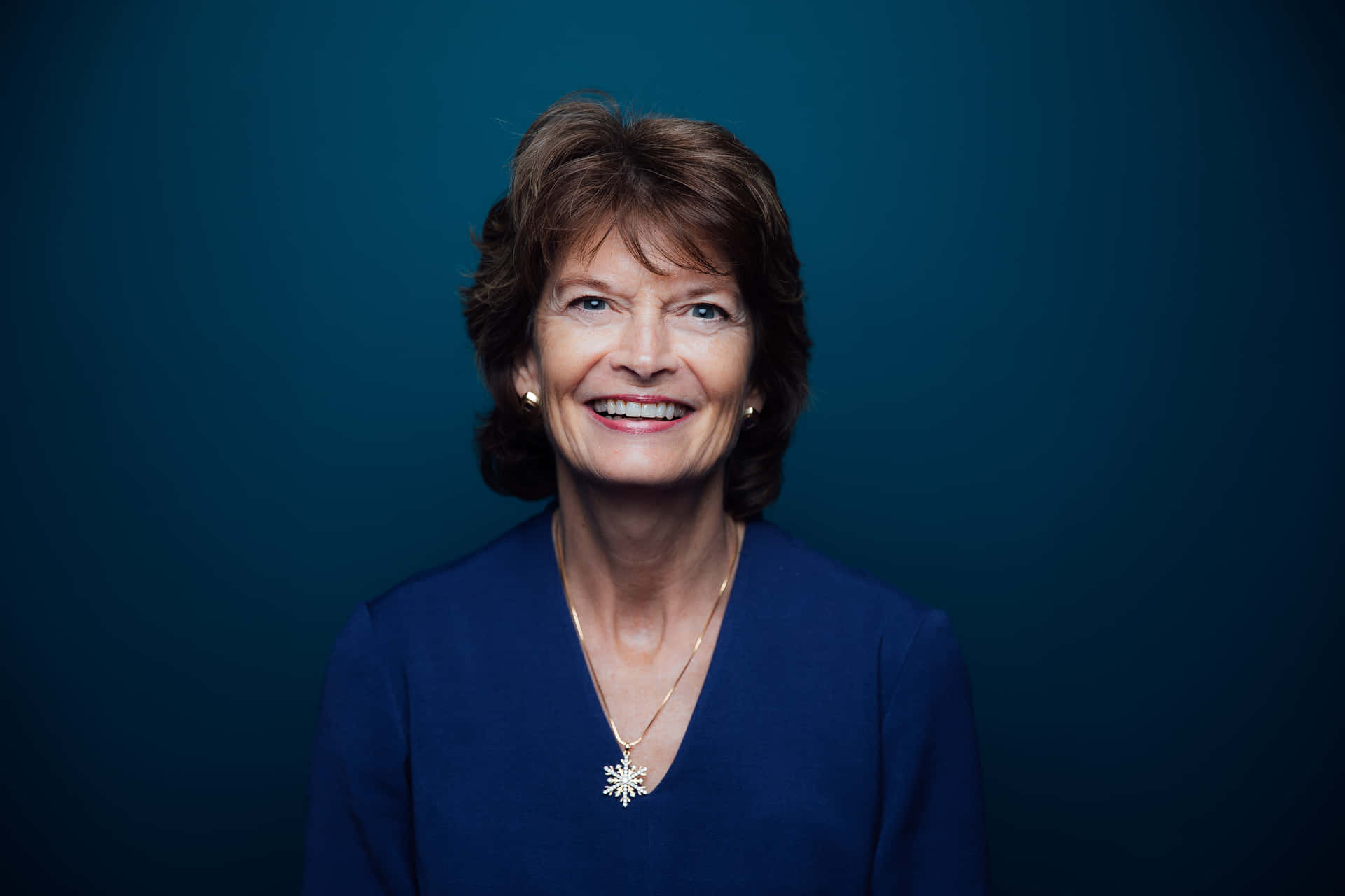 Senator Lisa Murkowski Smiling Against a Blue Aesthetic Background Wallpaper