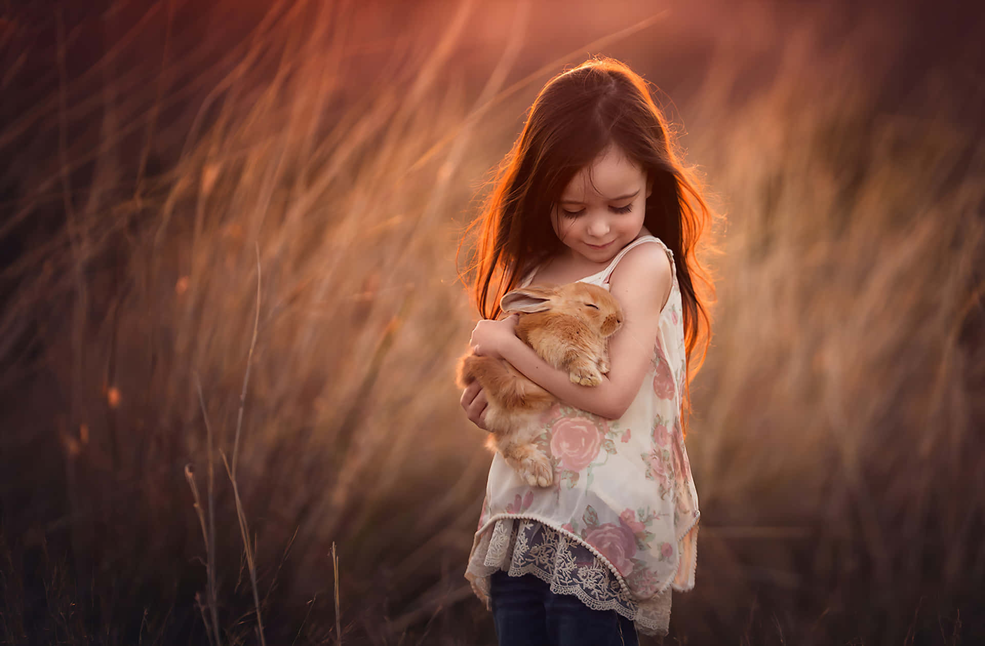 Little Girl Holding Rabbitin Sunset Field Wallpaper