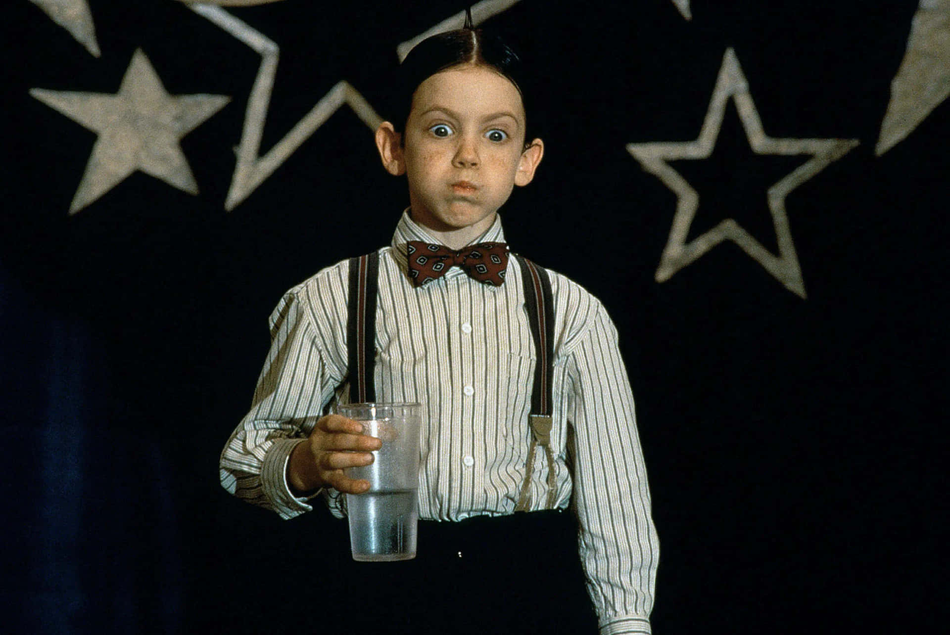 A Boy Holding A Glass Of Water