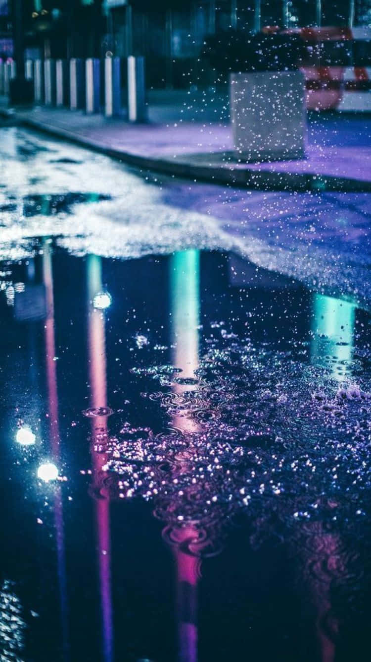 A Puddle Of Water On A Street At Night Wallpaper