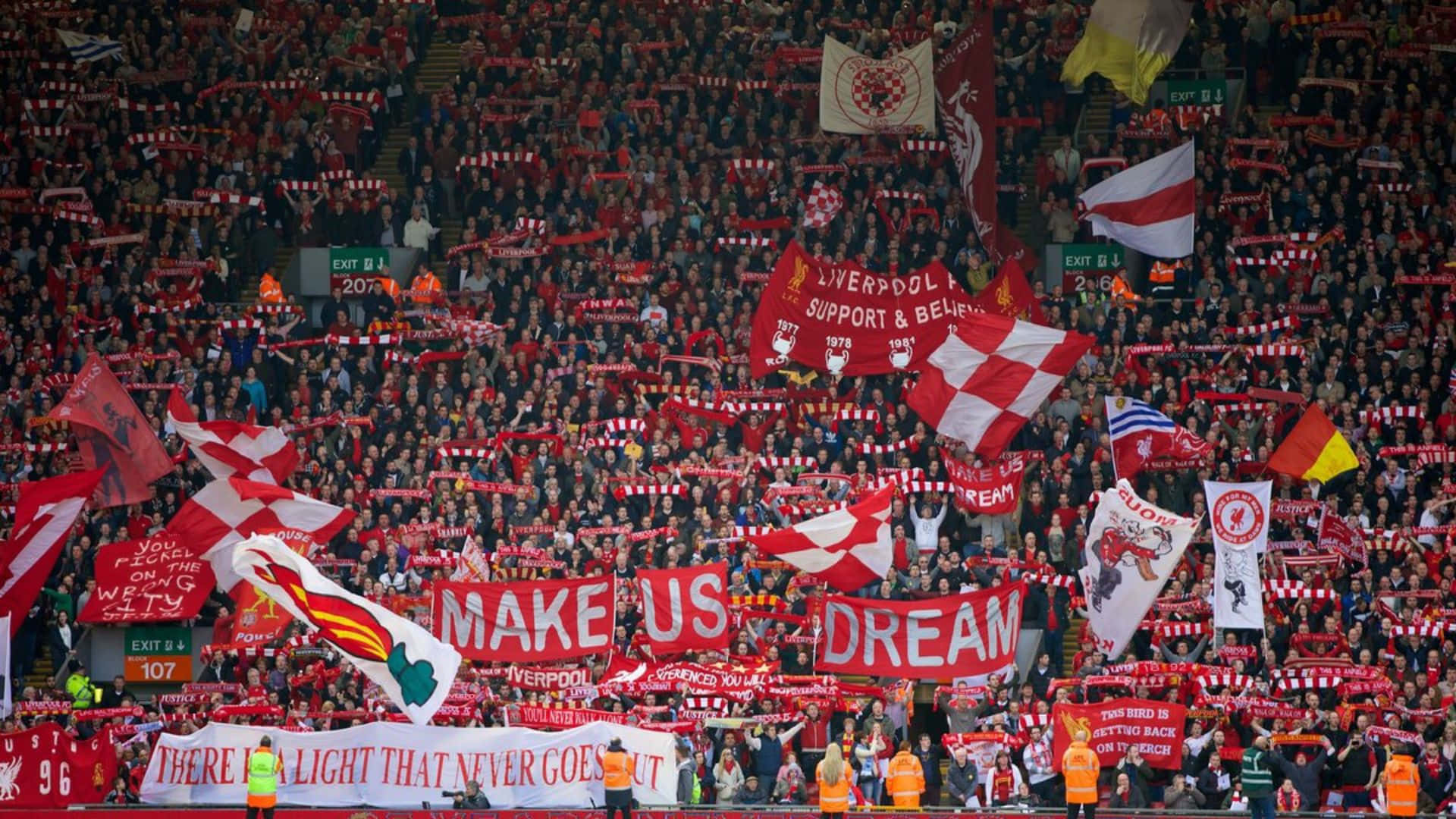 Aficionadosdel Liverpool Vistiendo Rojo Y Blanco Sosteniendo Banderas. Fondo de pantalla