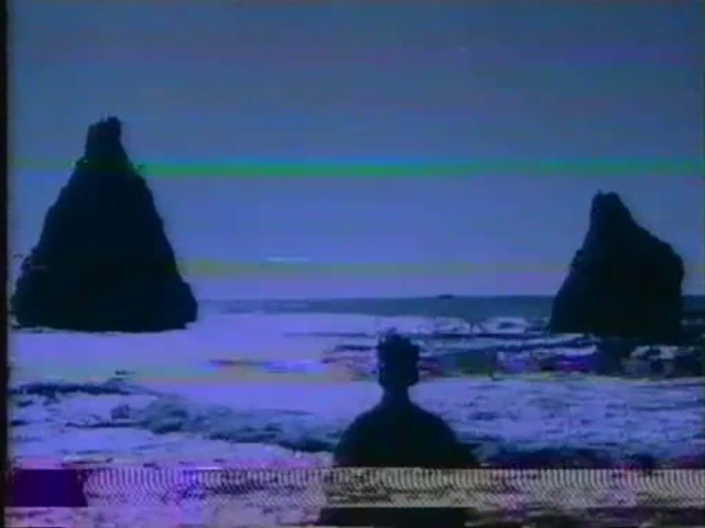 Et tv-skærm, der viser en gruppe af klipper ved stranden Wallpaper