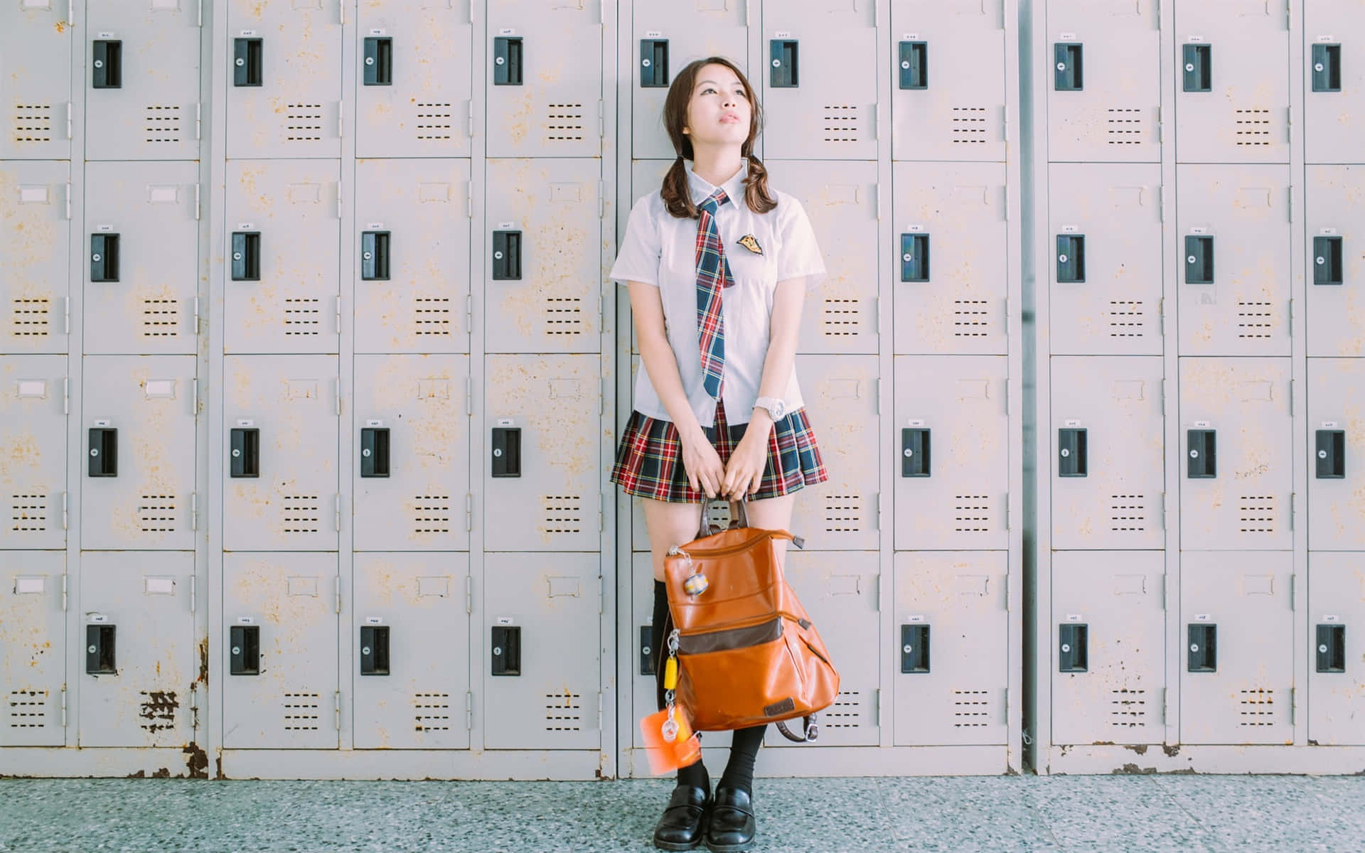 A Girl In School Uniform Standing In Front Of Lockers