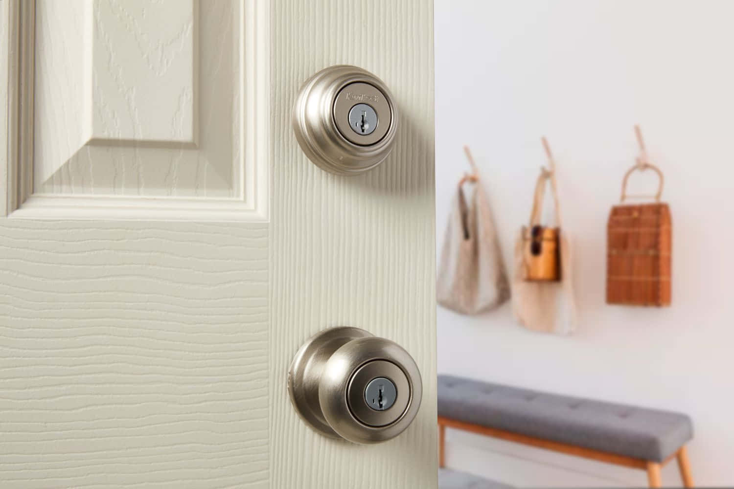 A Door With Two Knobs And A Bag Hanging On It