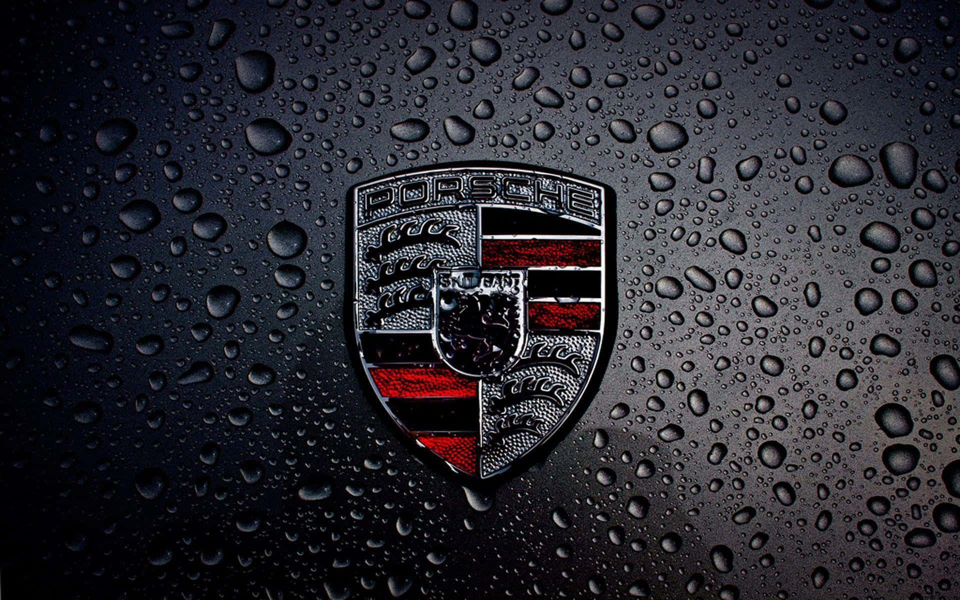 Porschelogo Auf Einem Schwarzen Auto Mit Regentropfen