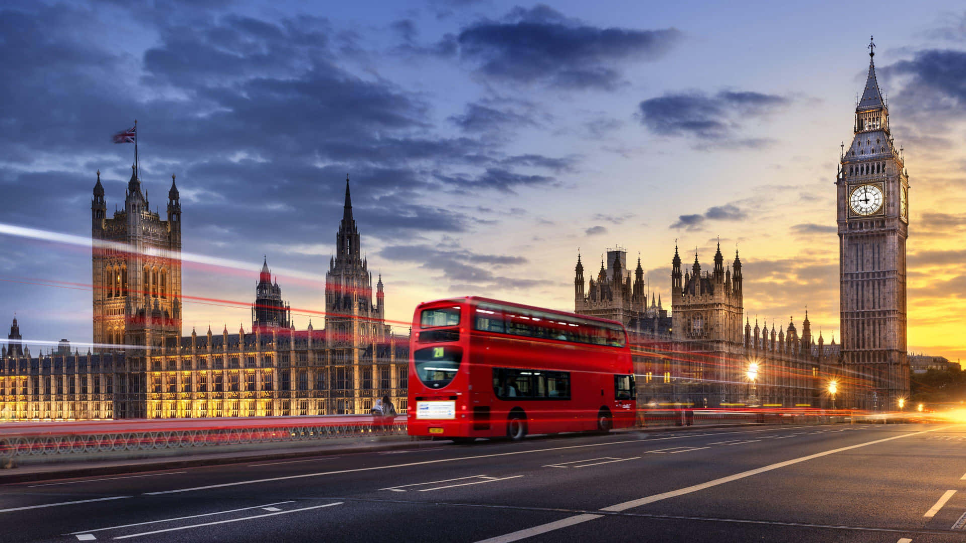 A Double Decker Bus Is Driving Past Big Ben And The Houses Of Parliament