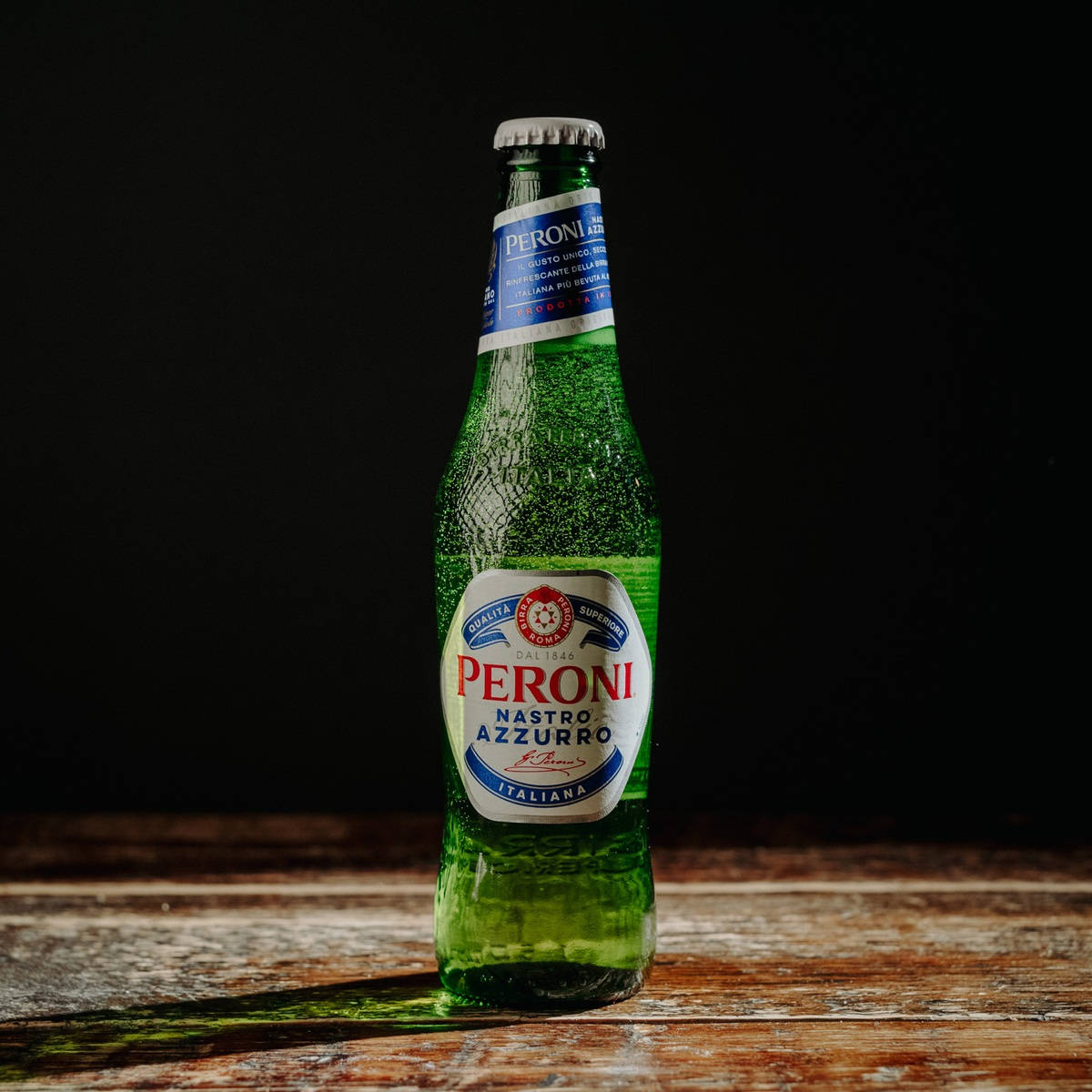 Lone Bottle Of Peroni Beer On A Black Background Wallpaper