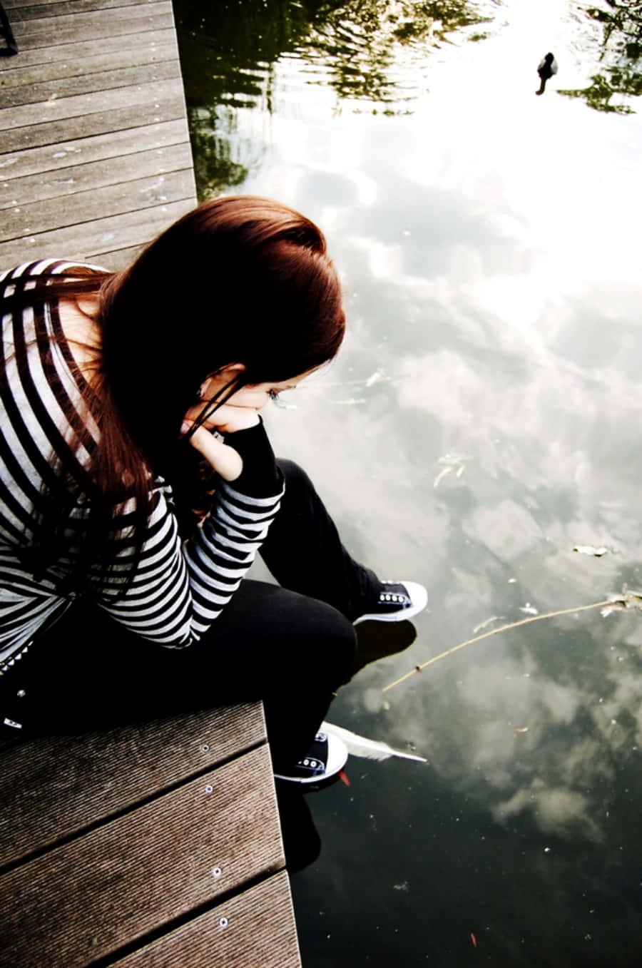 A Girl Sitting On A Dock
