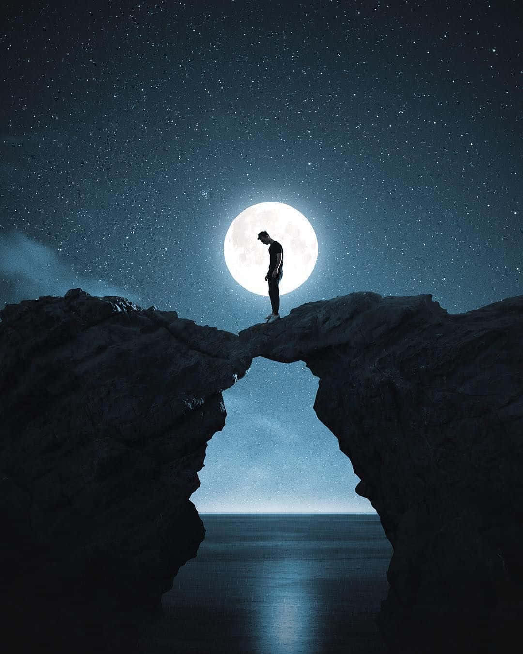 A Man Standing On A Rock In The Night Sky