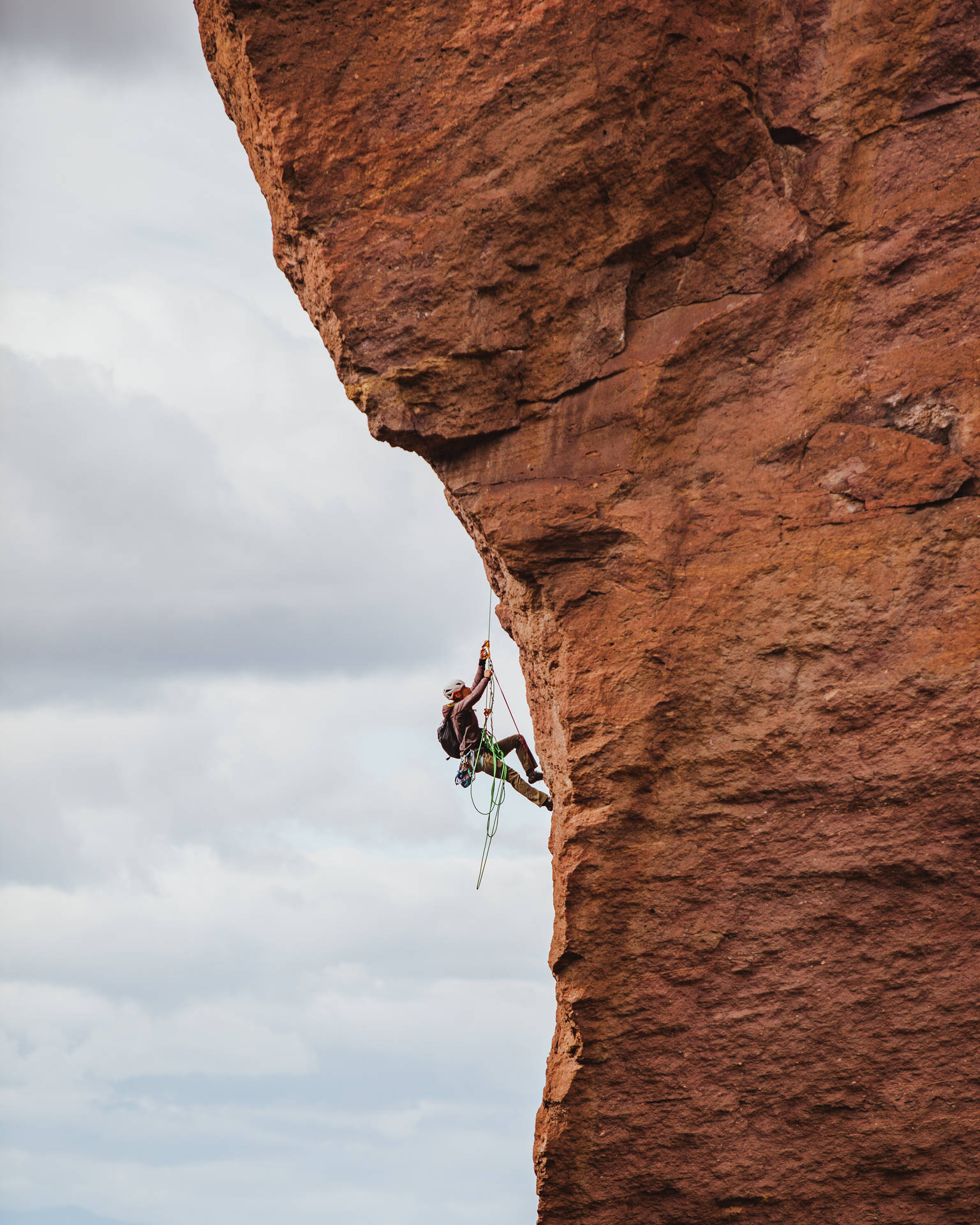 Long Shot Of A Man Rock Climbing Wallpaper