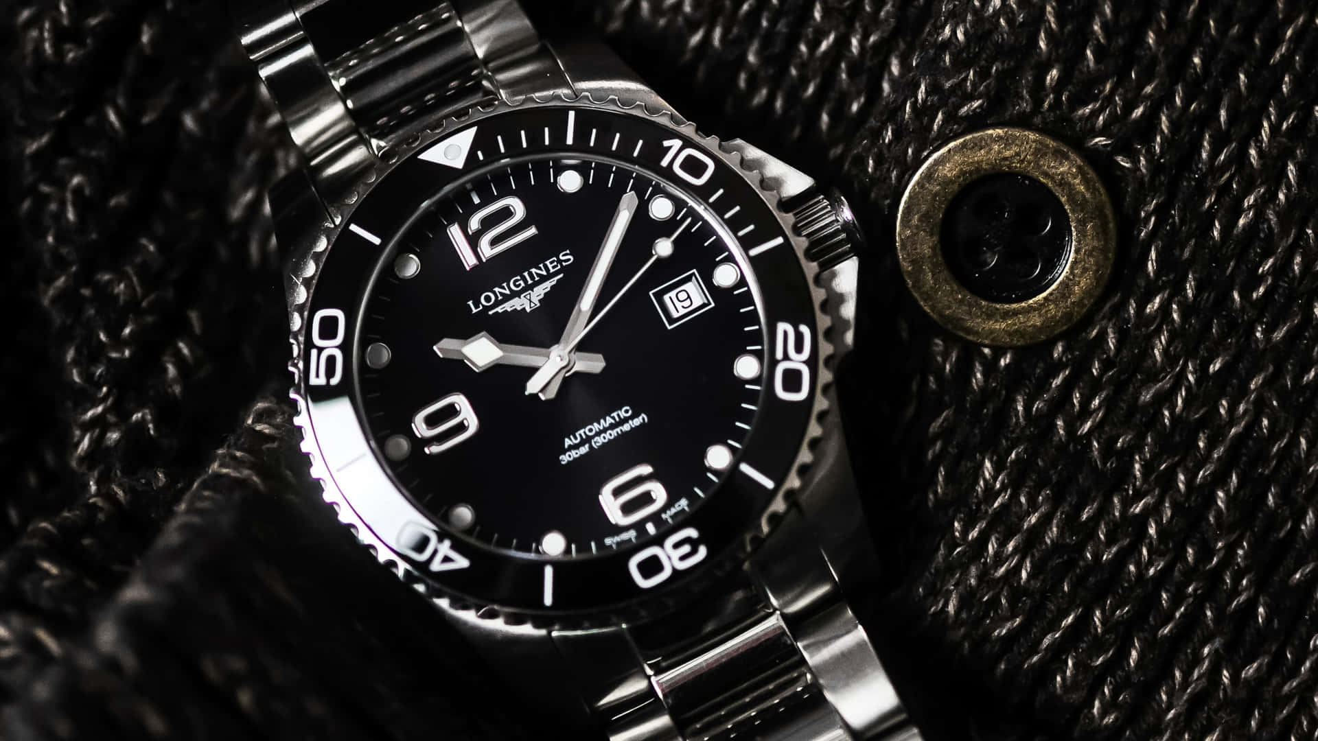 Longines HydroConquest Watch Placed On A Fabric Wallpaper