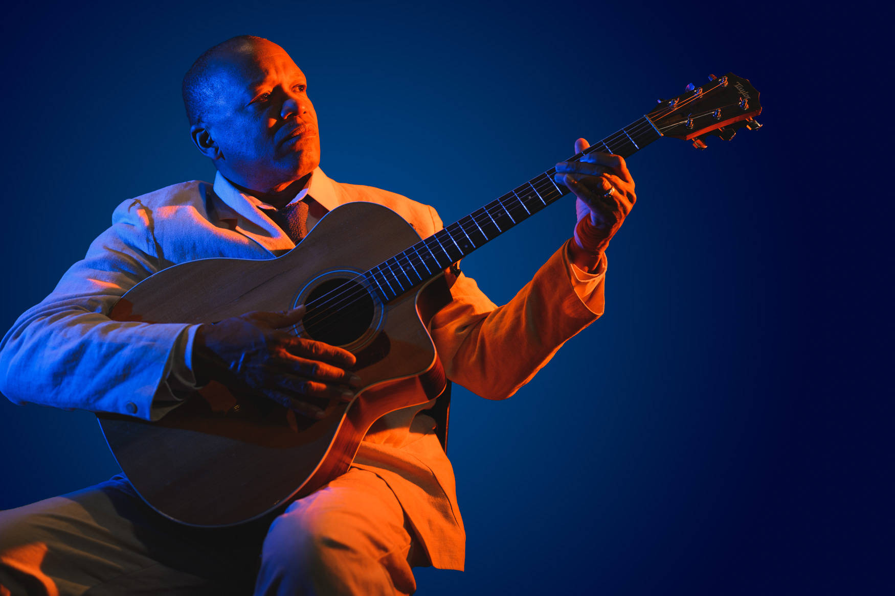 Download Lonnie Johnson With A Guitar On A Dark Blue Wallpaper | Wallpapers .com