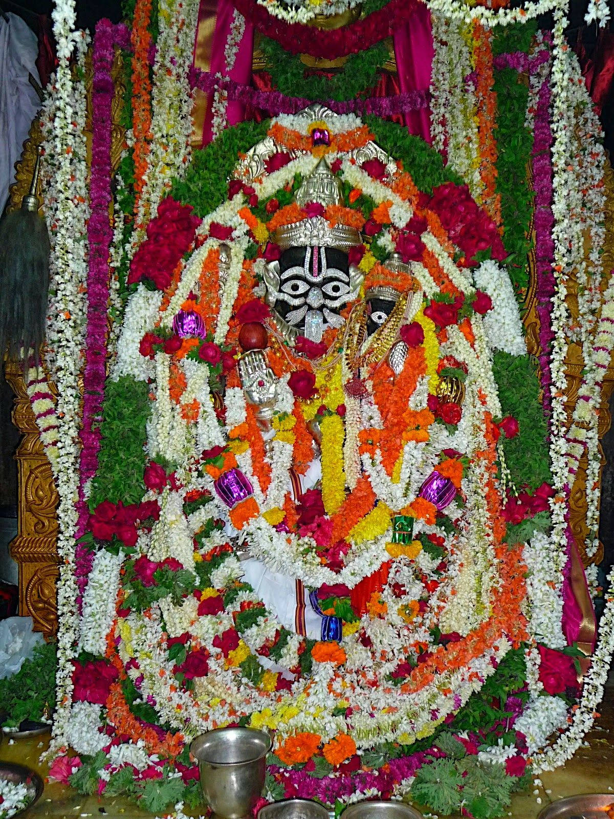 Lord Lakshmi Narasimha Statue Dækket Med Krans Af Blomster Wallpaper