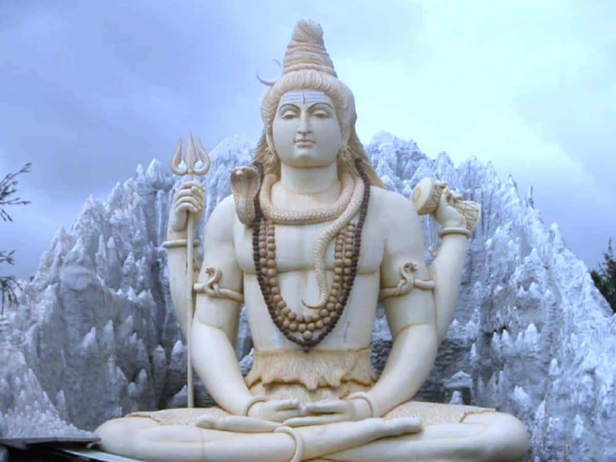 A Statue Of Lord Shiva Sitting In Front Of A Mountain