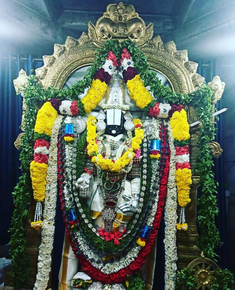 Sacred Statue of Lord Venkateswara Adorned with Floral Garlands Wallpaper