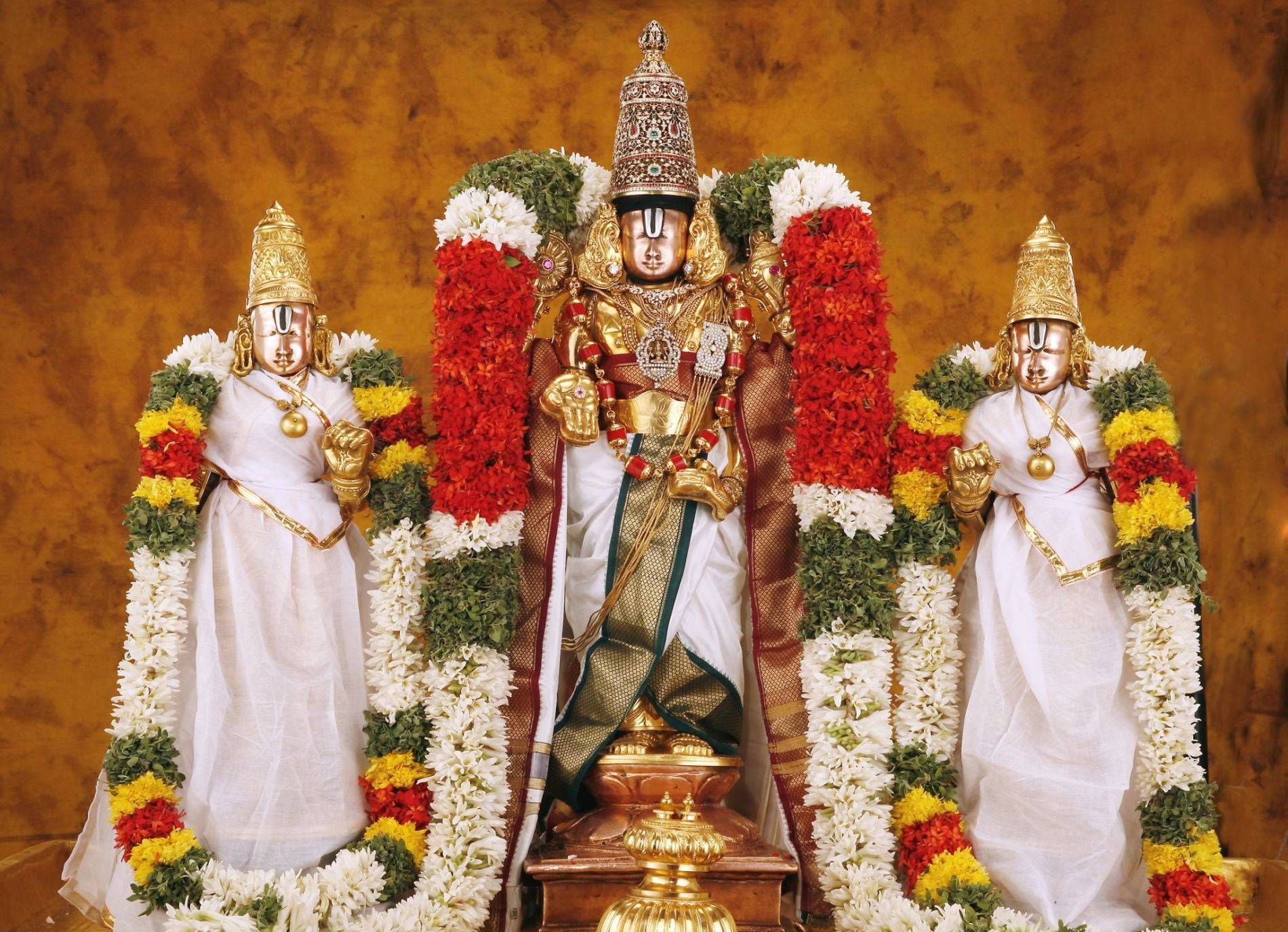 Lord Venkateswara With Two Statues And Garlands Wallpaper
