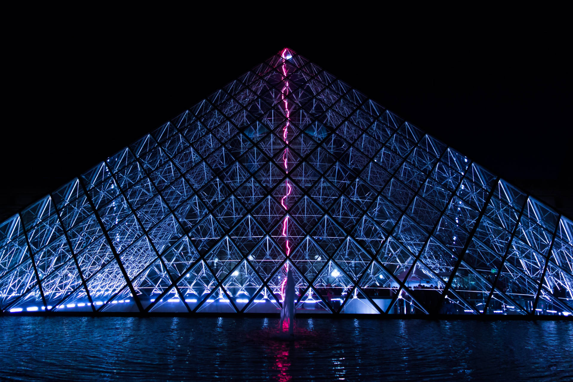A modern-day grand spectacle of Paris—the Louvre Museum at night Wallpaper