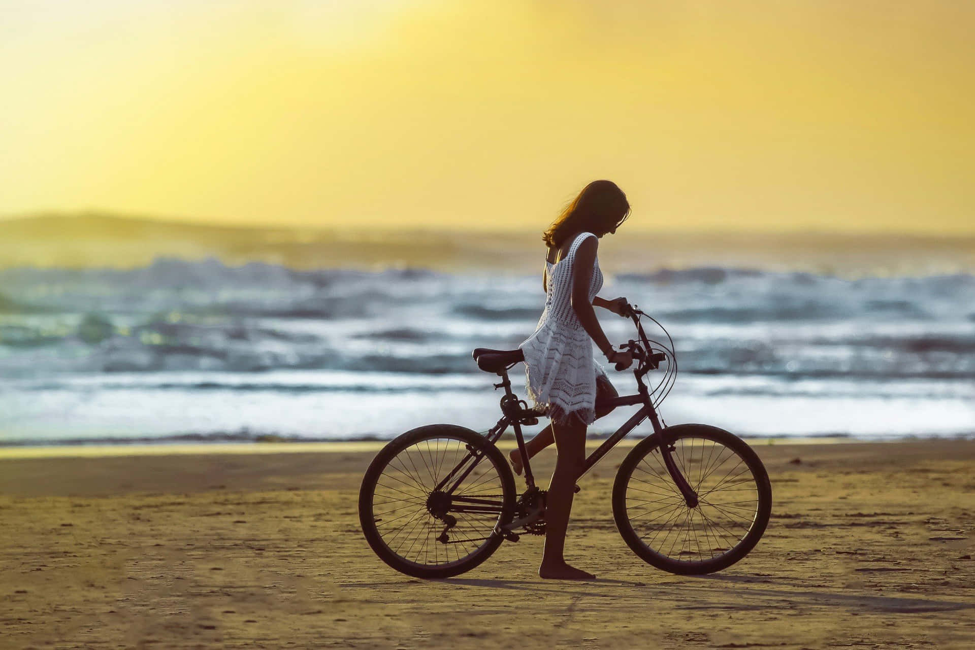 Ragazzaadorabile Sulla Spiaggia Che Guida La Bicicletta. Sfondo