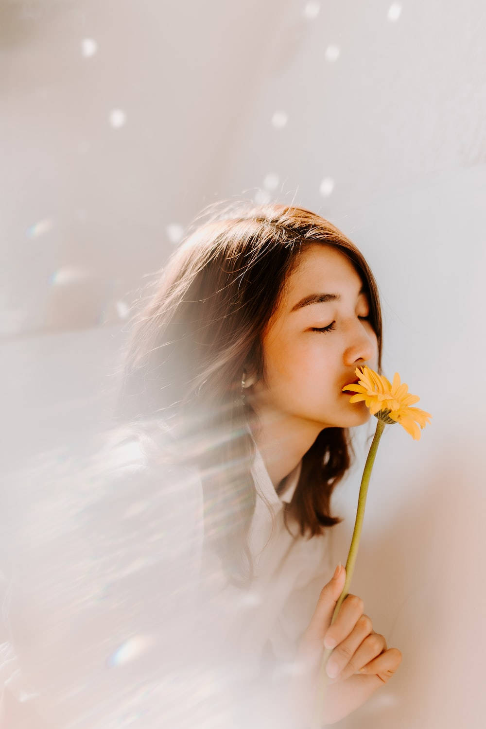 Sød pige sniffer en gul blomst Wallpaper