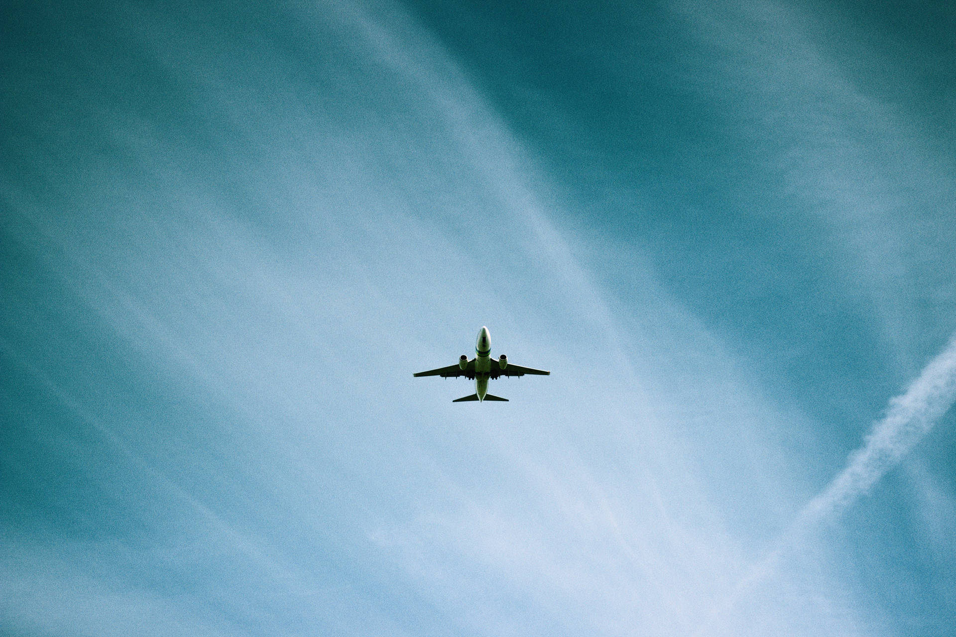 A low angle view of a plane flying through the sky Wallpaper