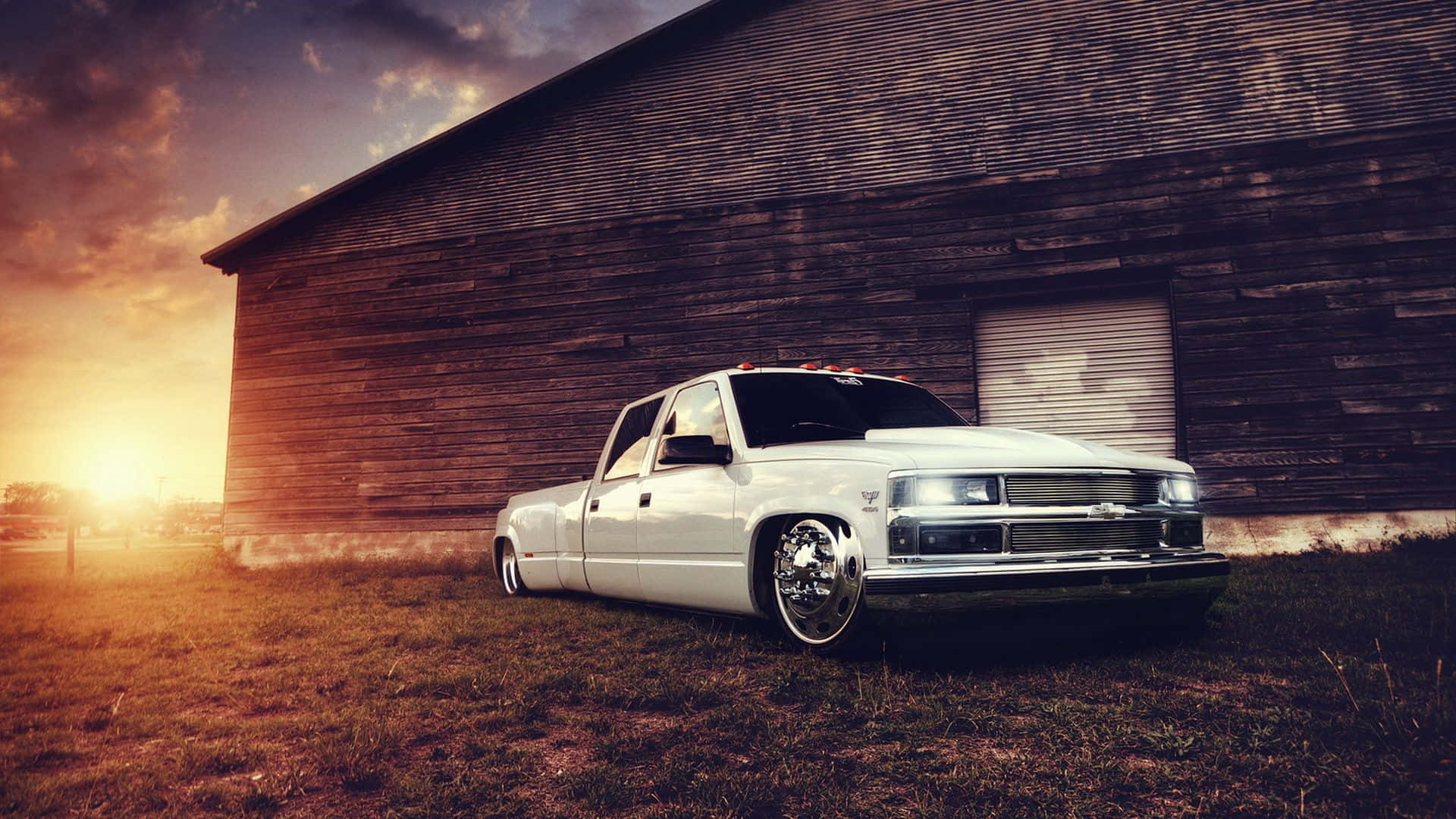 A White Truck Parked In Front Of A Barn Wallpaper