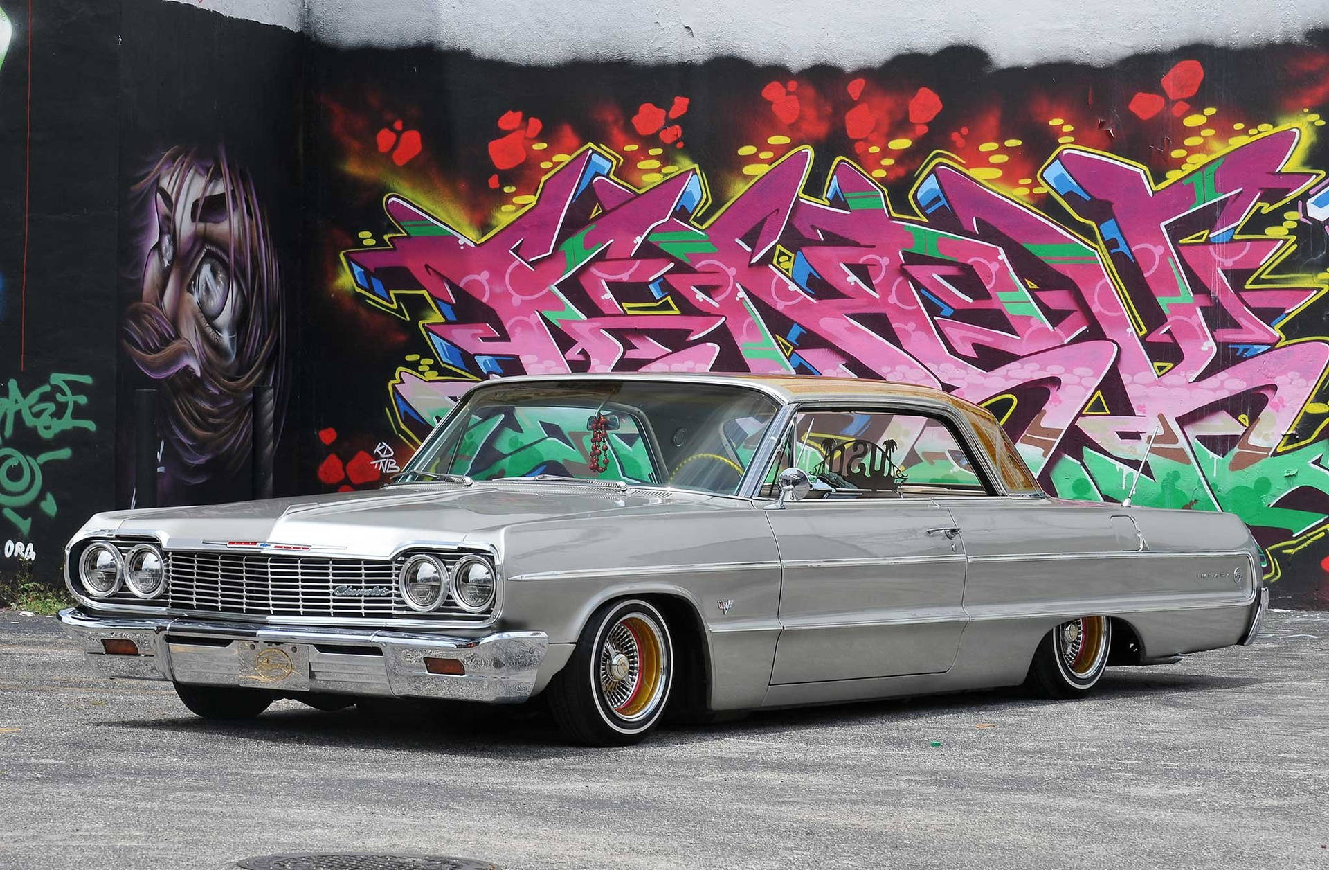 Lowrider Impala Against Colorful Mural Wallpaper