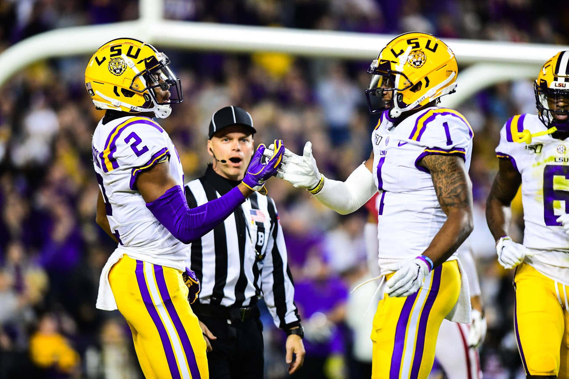 Lsu Football Players Are Celebrating After A Touchdown Wallpaper