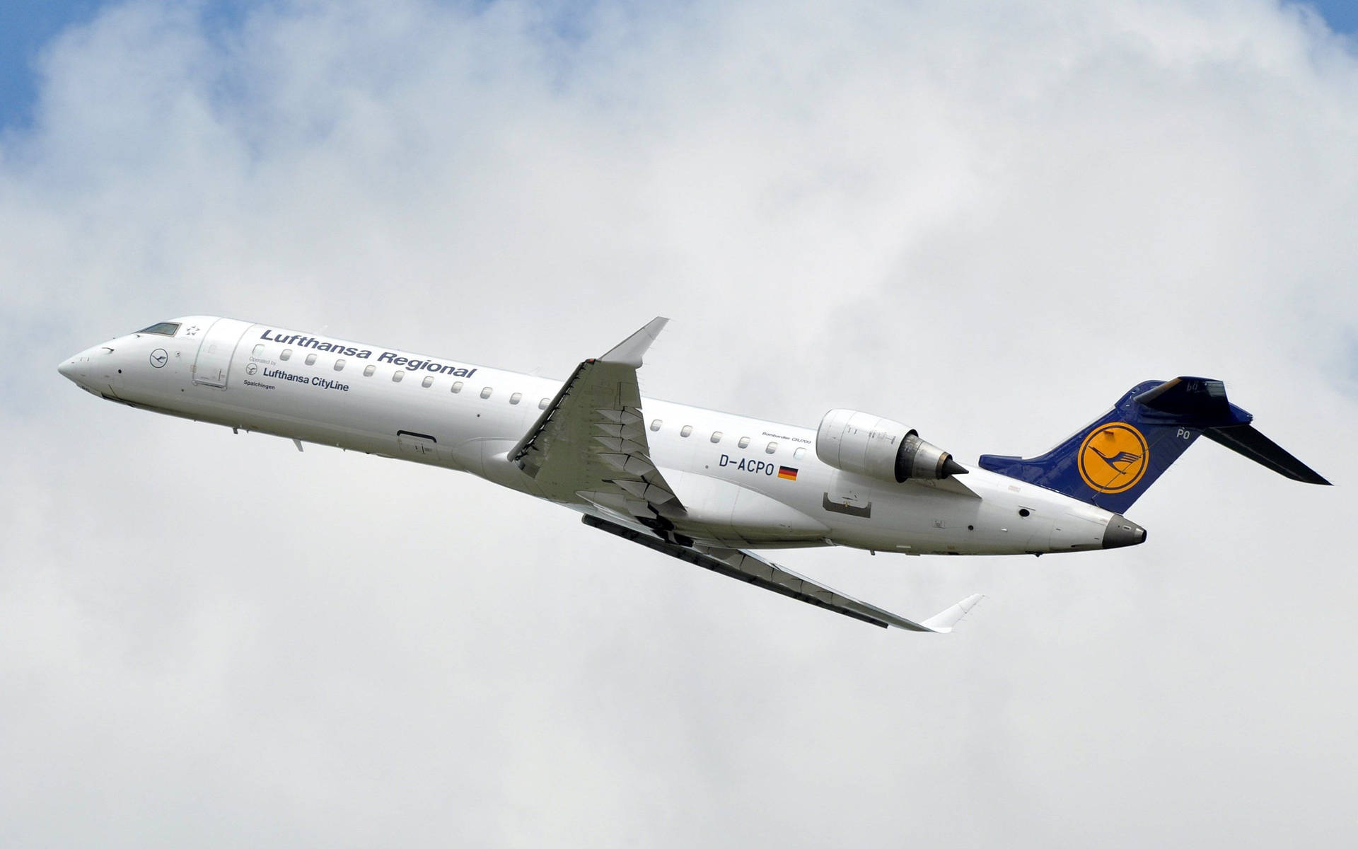Luftfartøj fra Lufthansa blandt bomuldskyer. Wallpaper