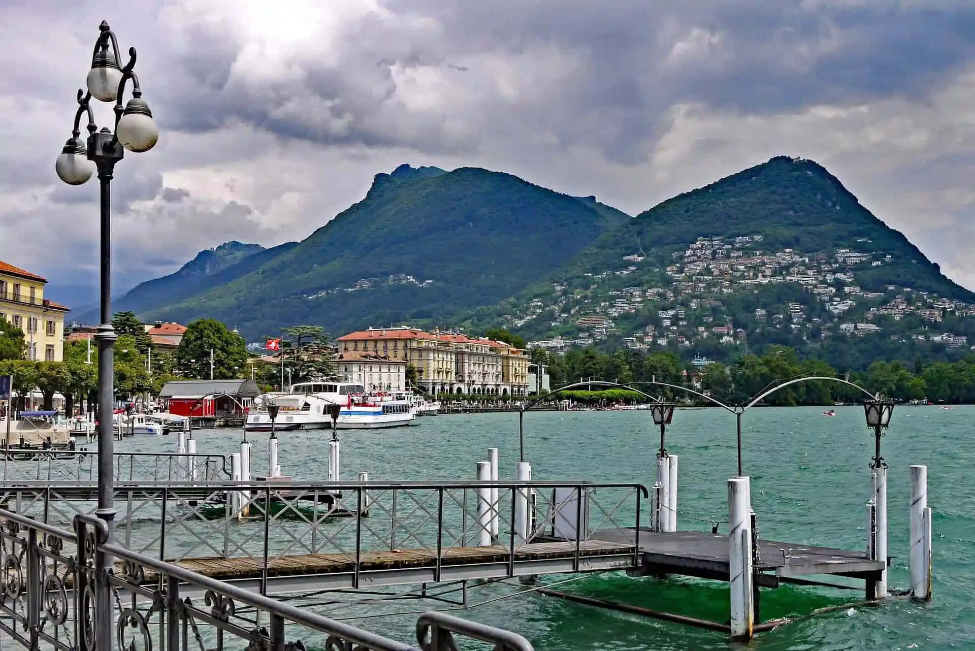 Lugano Lakefront Viewwith Mountains Wallpaper