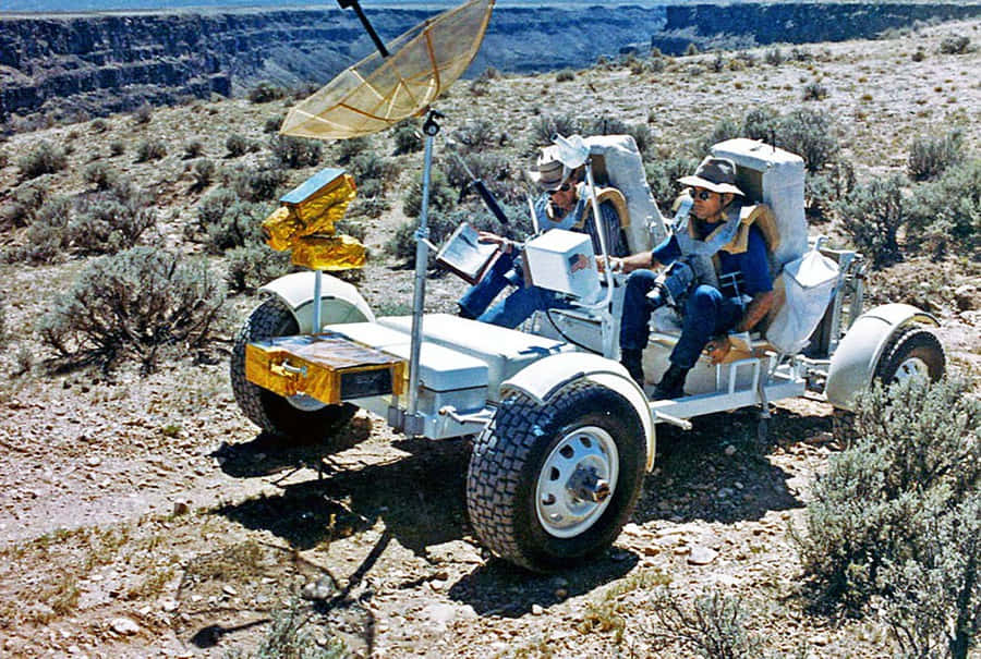 Astronaut driving the Lunar Rover on the moon's surface Wallpaper