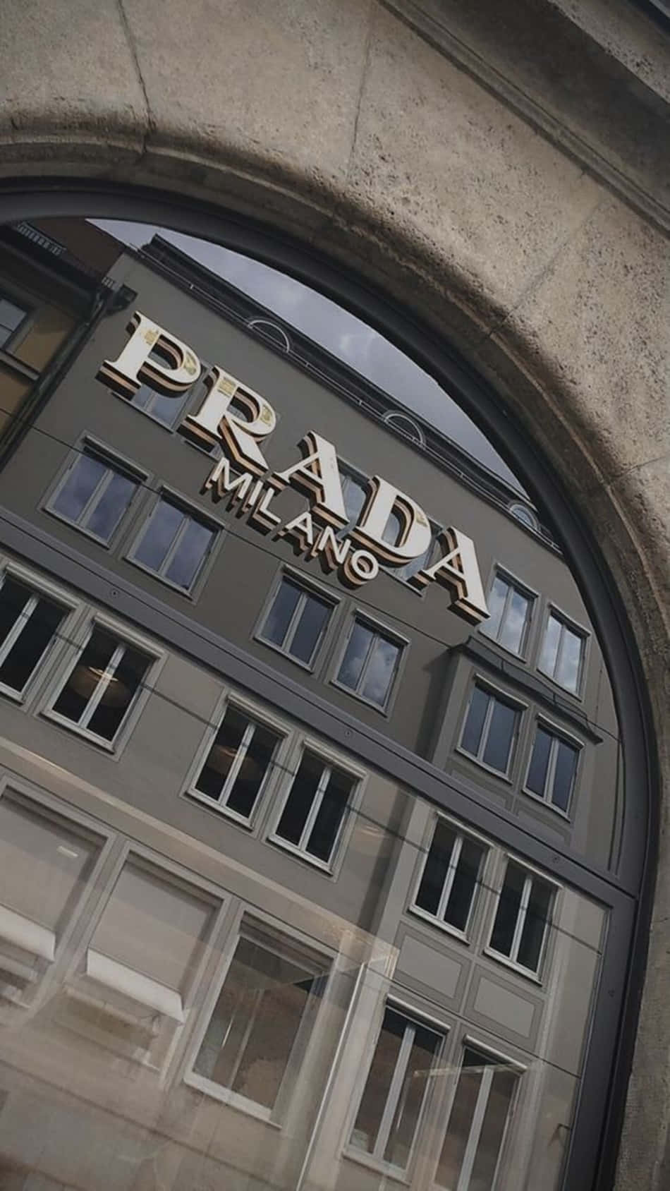 Prada - A Mirrored Building With A Sign Wallpaper
