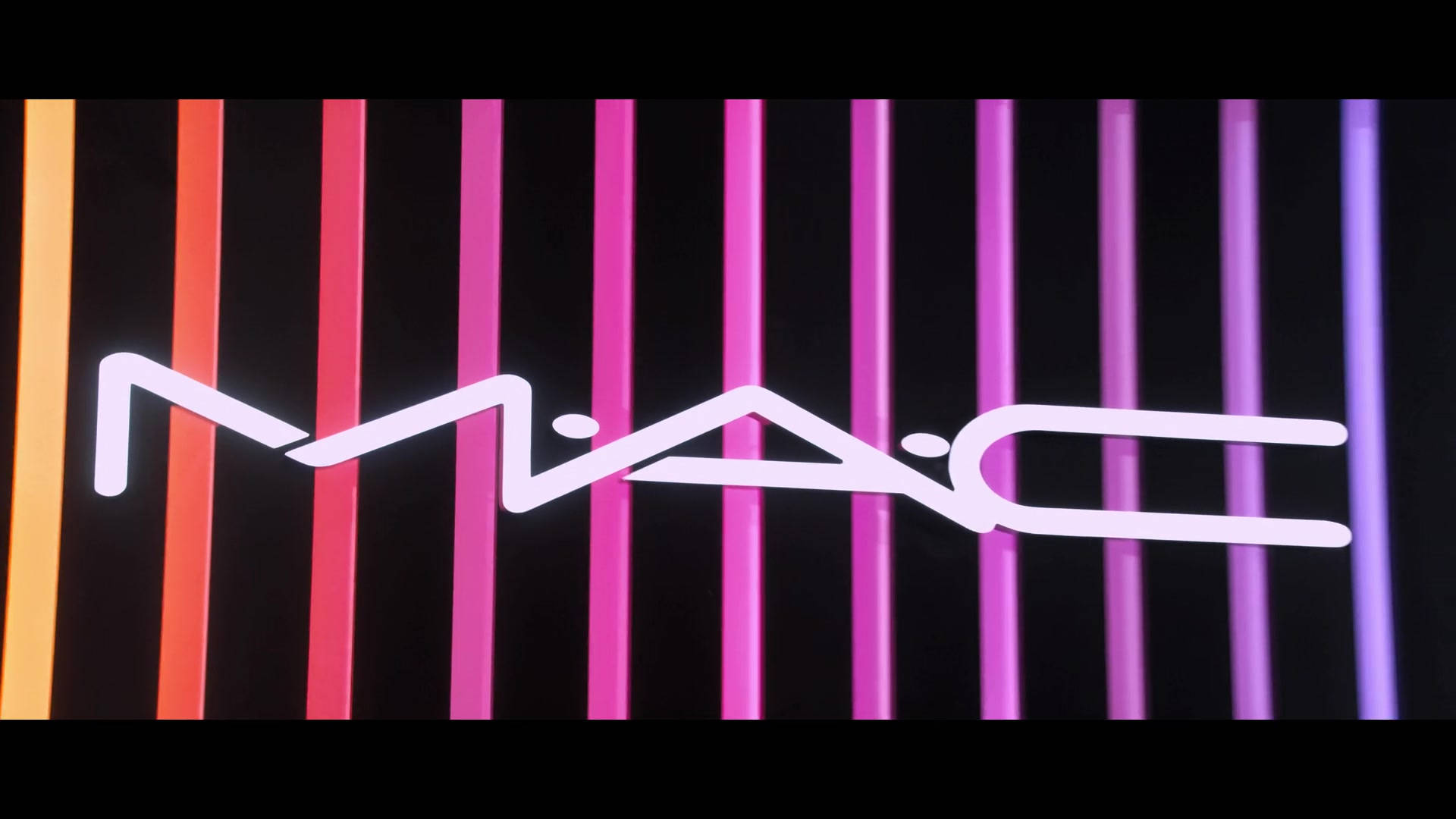 Mac Cosmetics Neon Logo Tapet: Skab et moderne og frisk udseende med dette Mac-logo tapet i neonfarver. Wallpaper
