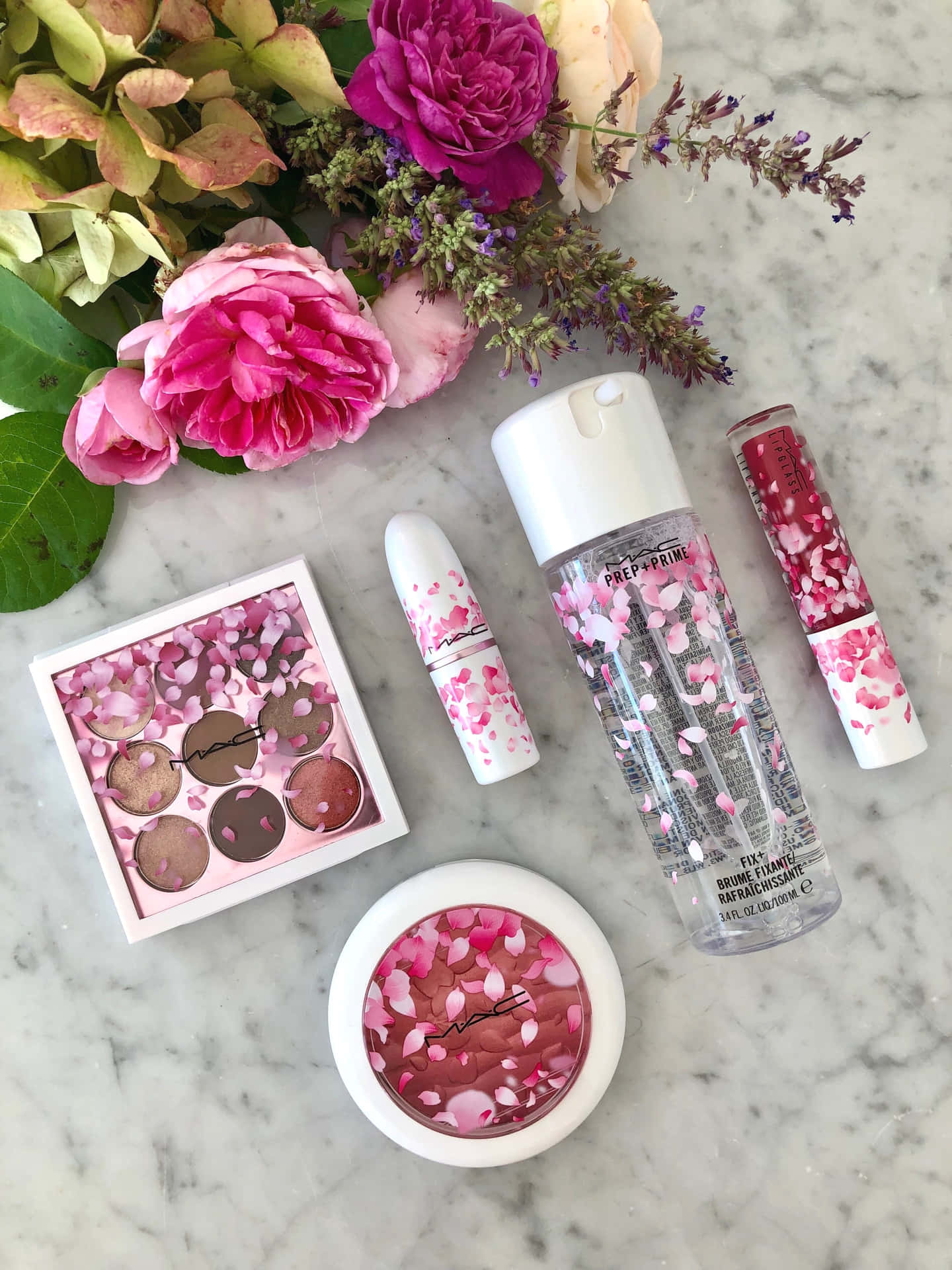 A Pink Flower And Cosmetics On A Marble Table