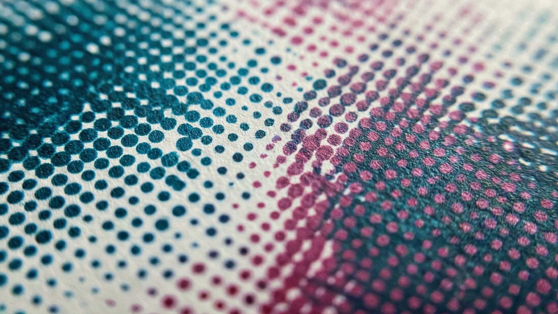 Macro close-up of halftone dot grid with cyan and magenta dots on paper