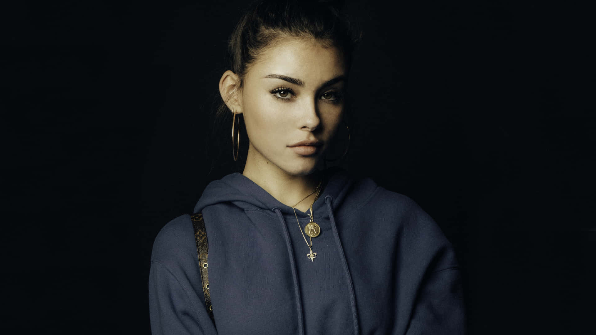 A Young Woman In A Blue Hoodie Posing For A Photo Wallpaper