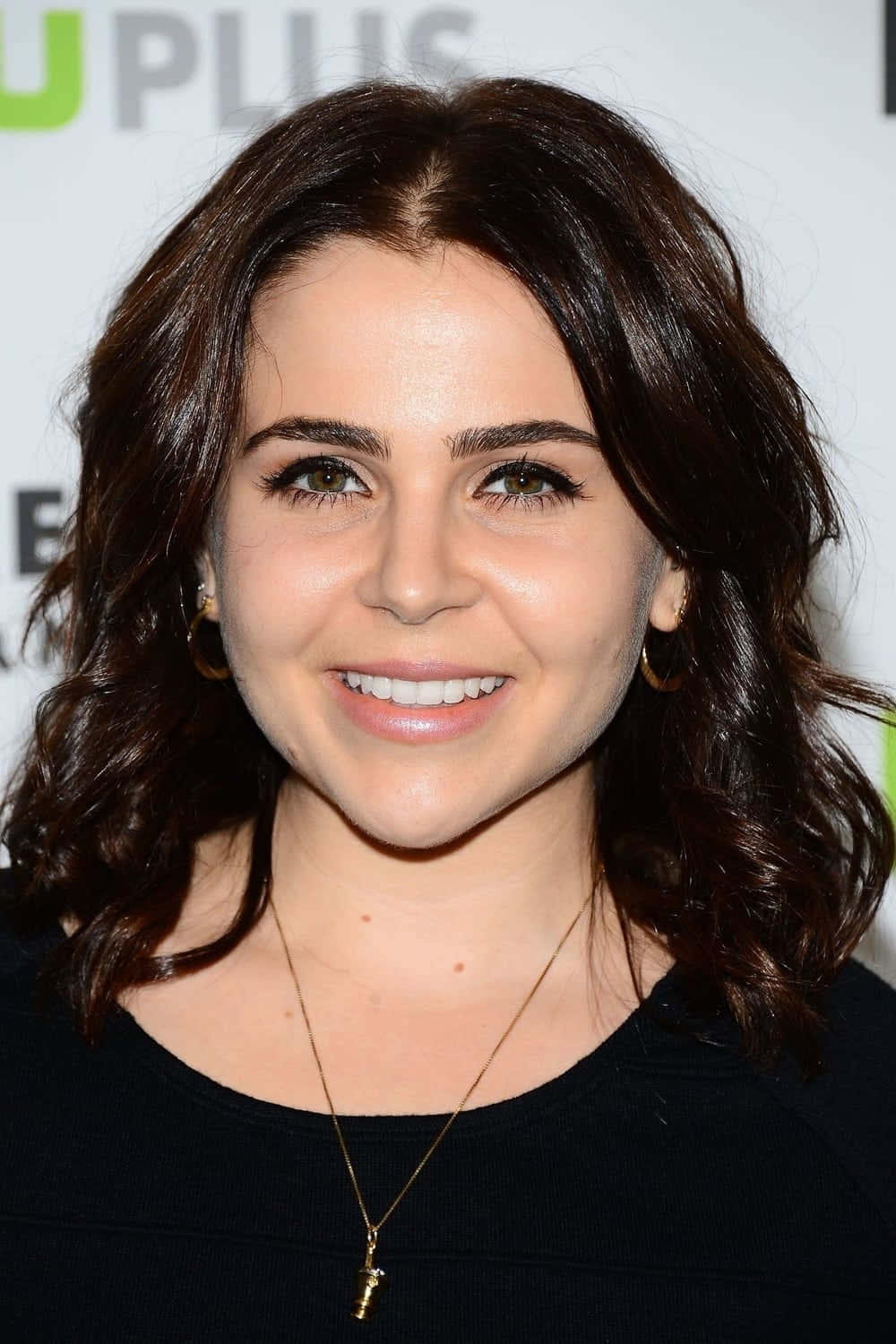 Mae Whitman posing confidently in a stylish outfit Wallpaper
