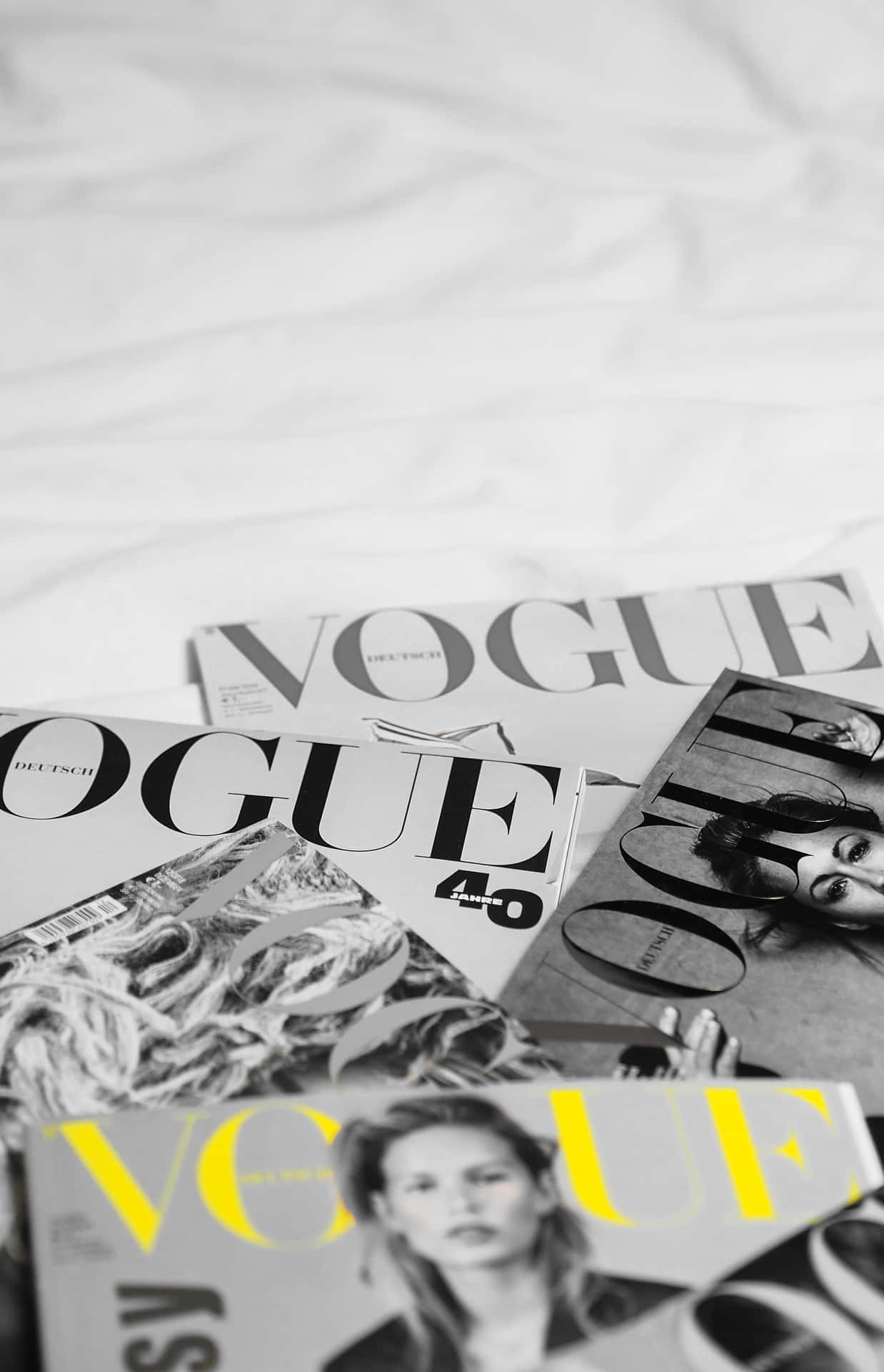 Voguetidningen På En Säng Med Ett Gult Överdrag