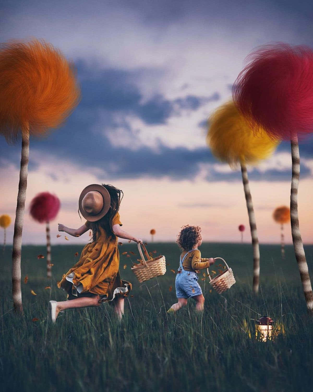 two children are running in a field with colorful pom poms