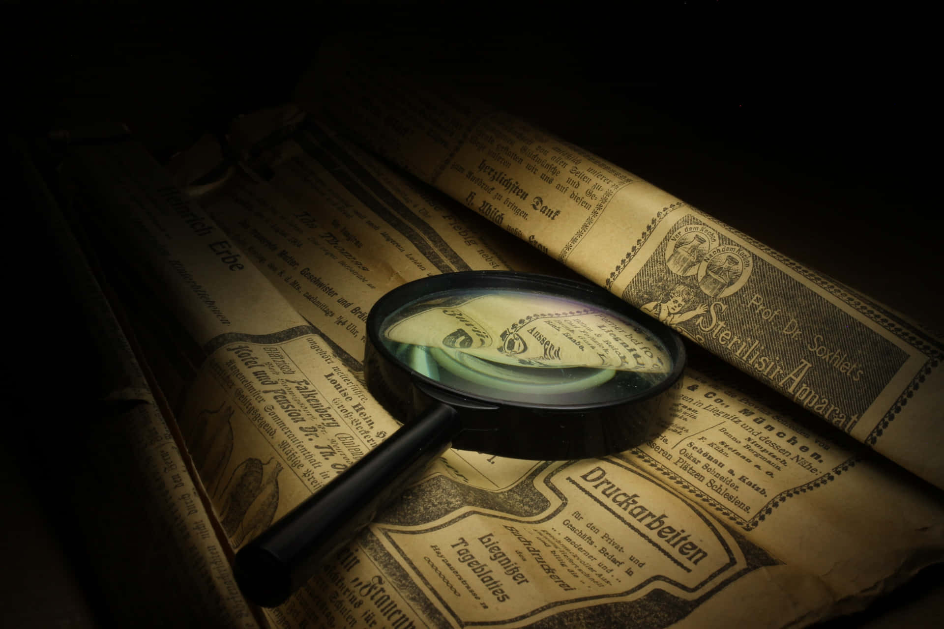 Close-up of a Magnifying Glass on a Newspaper Article Wallpaper